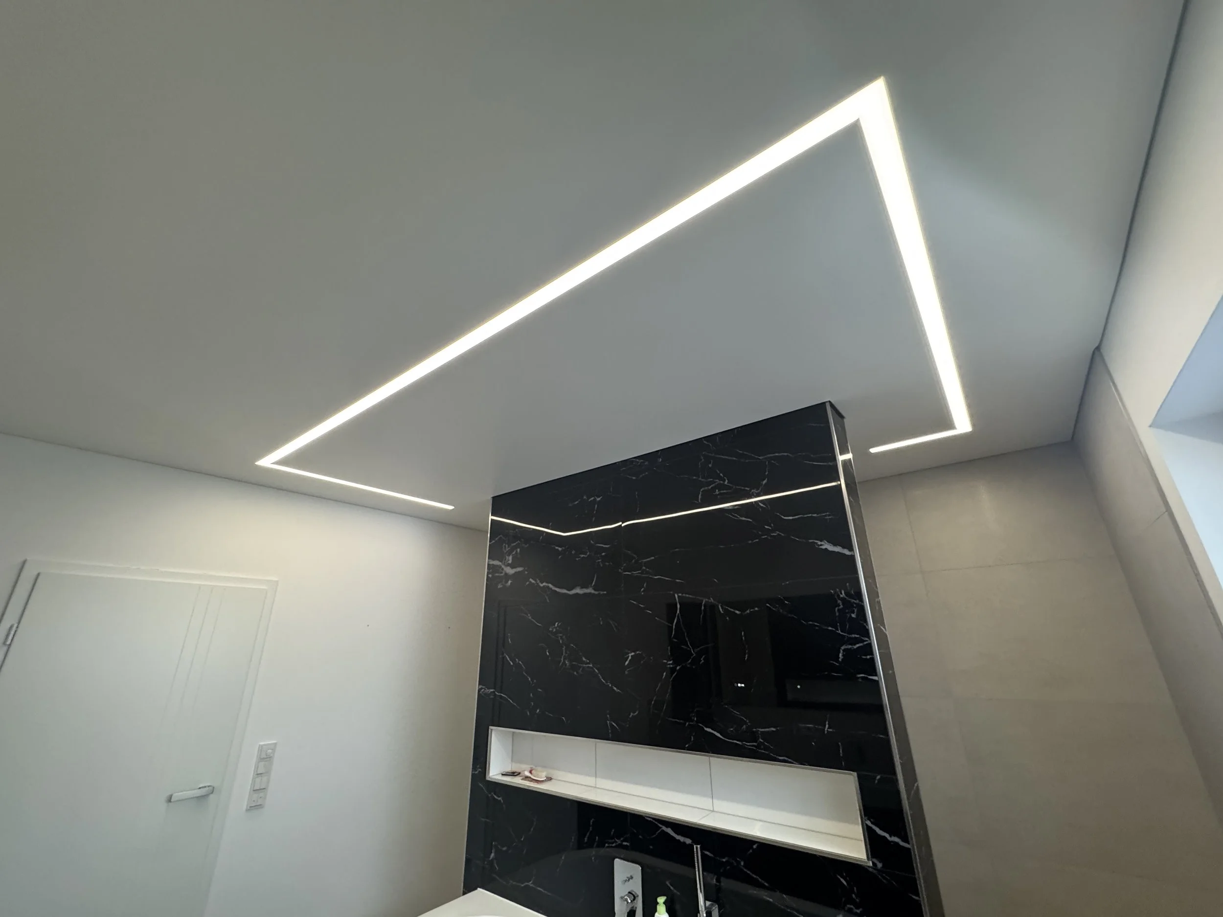 Moderne Deckenbeleuchtung in einem Raum, rechteckige LED-Lichtleisten in einem weißen und schwarzen Raum.