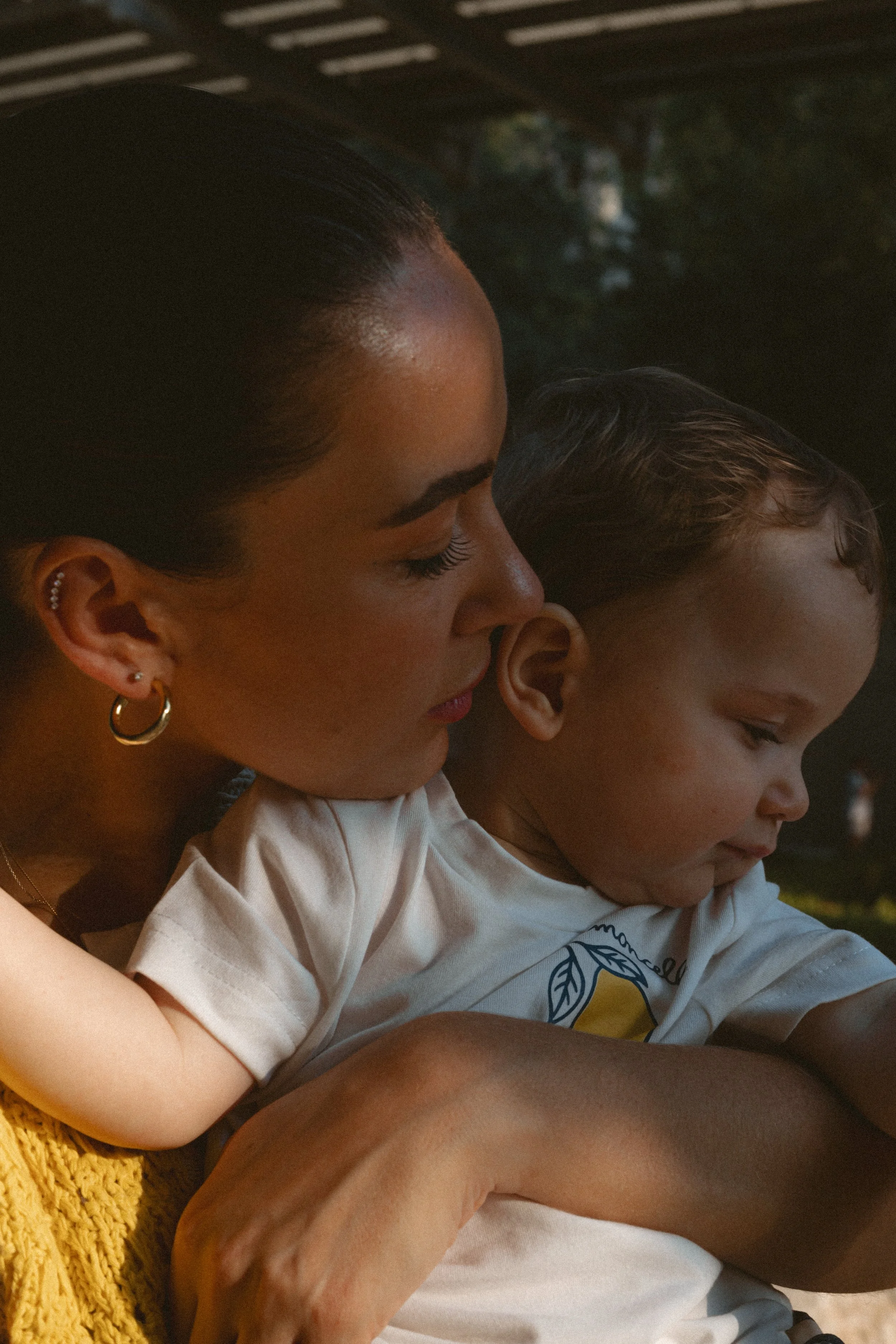 Mother holding her young child during an intimate family photography session outdoors in Dubai.