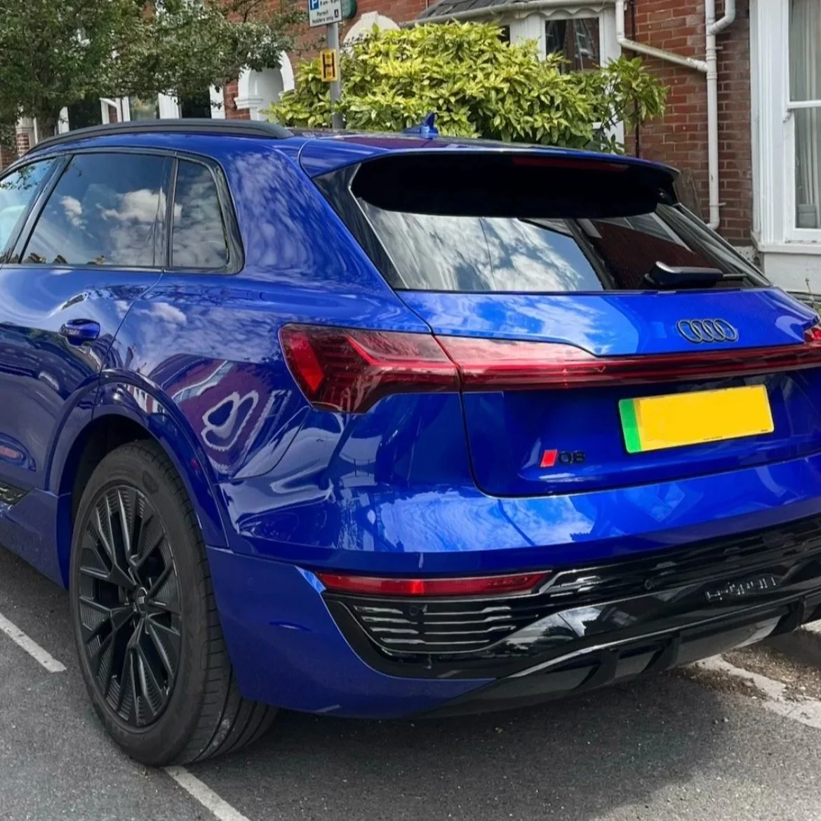 Blue Audi Q8 parked on the street in a residential neighborhood.