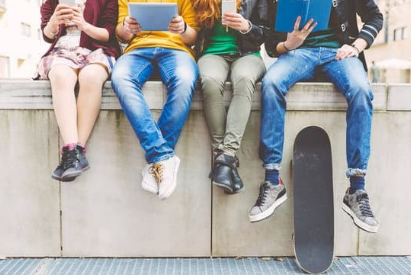 group of teenage friends sitting on wall