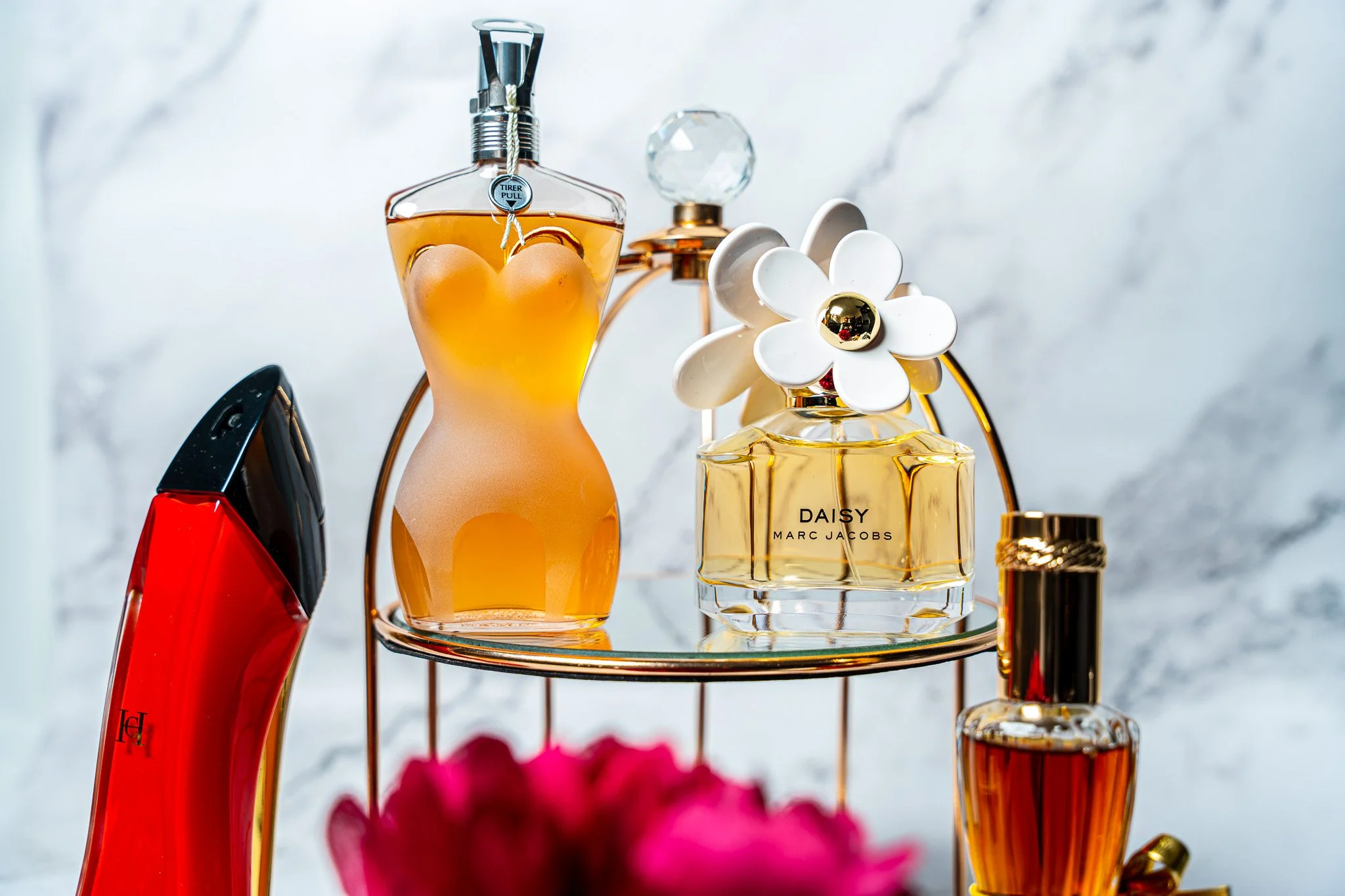 Group shot of perfumes including Daisy by Marc Jacobs, Youth Dew by Estee Lauder, Very Good Girl by Carolina Herrera & Gaultier Classique by Jean Paul.