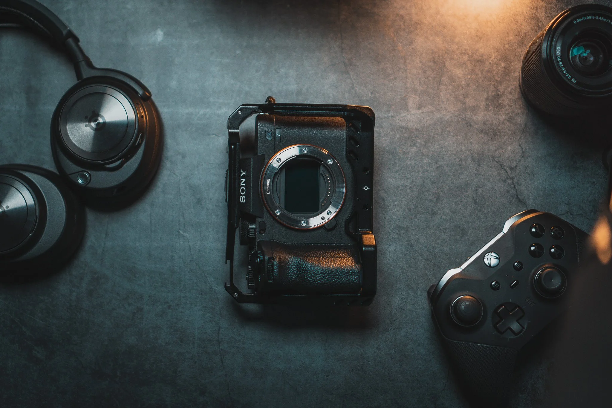 Tech Essentials on a Slate Grey Backdrop including Xbox controller, Arctis Headset & Sony A7IV