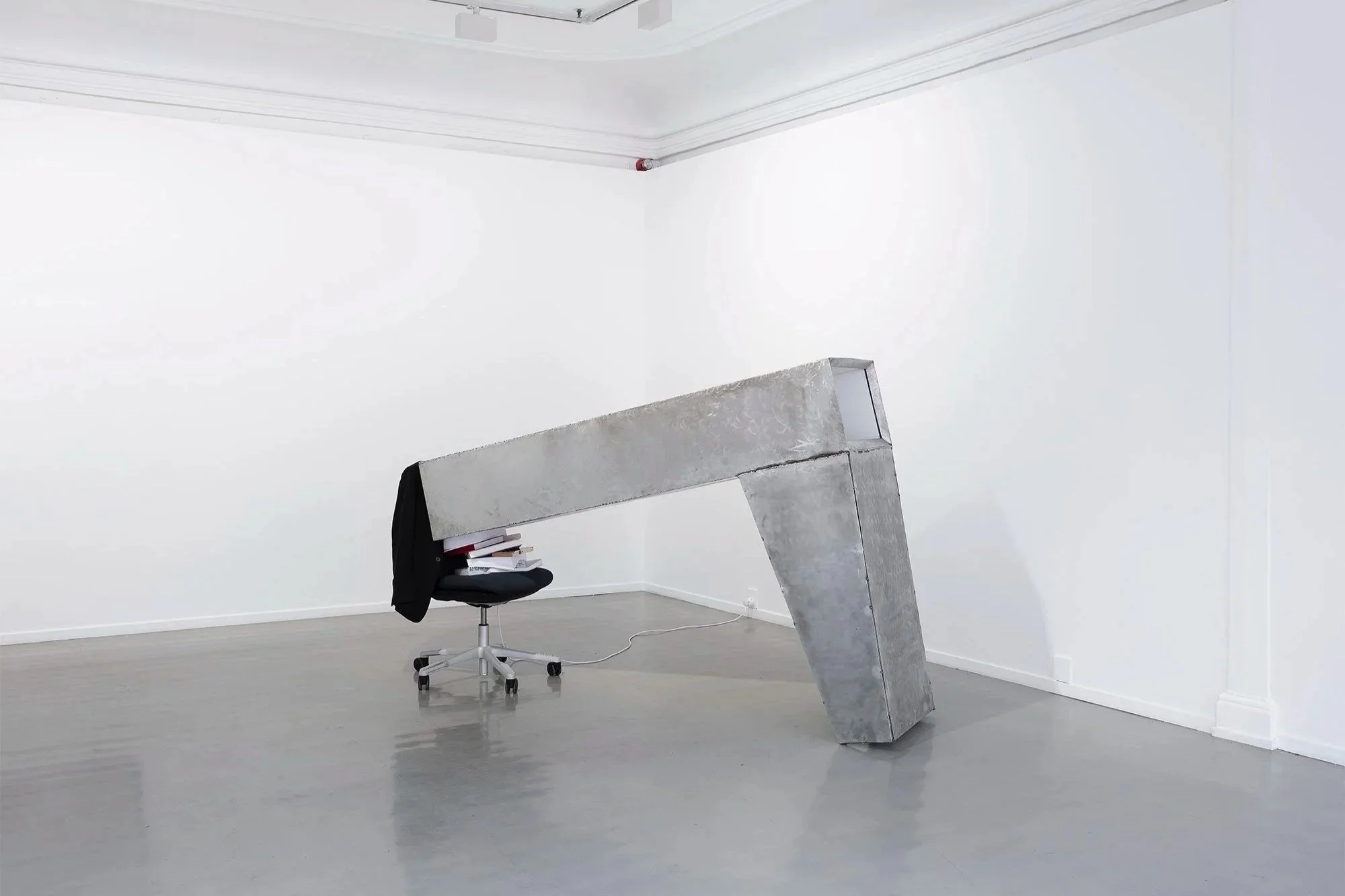 The help, 2026, video installation sculpture-Steel, wood, video moniter, office chair, jacket, books, paper, W45xH138xL200cm-Video duration 11:50sec