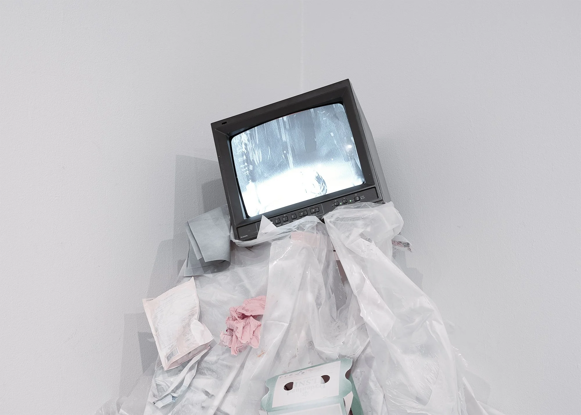 The ball, video installation, 2024, analog monitor, plastic, trash, cans, syringe, size variable 