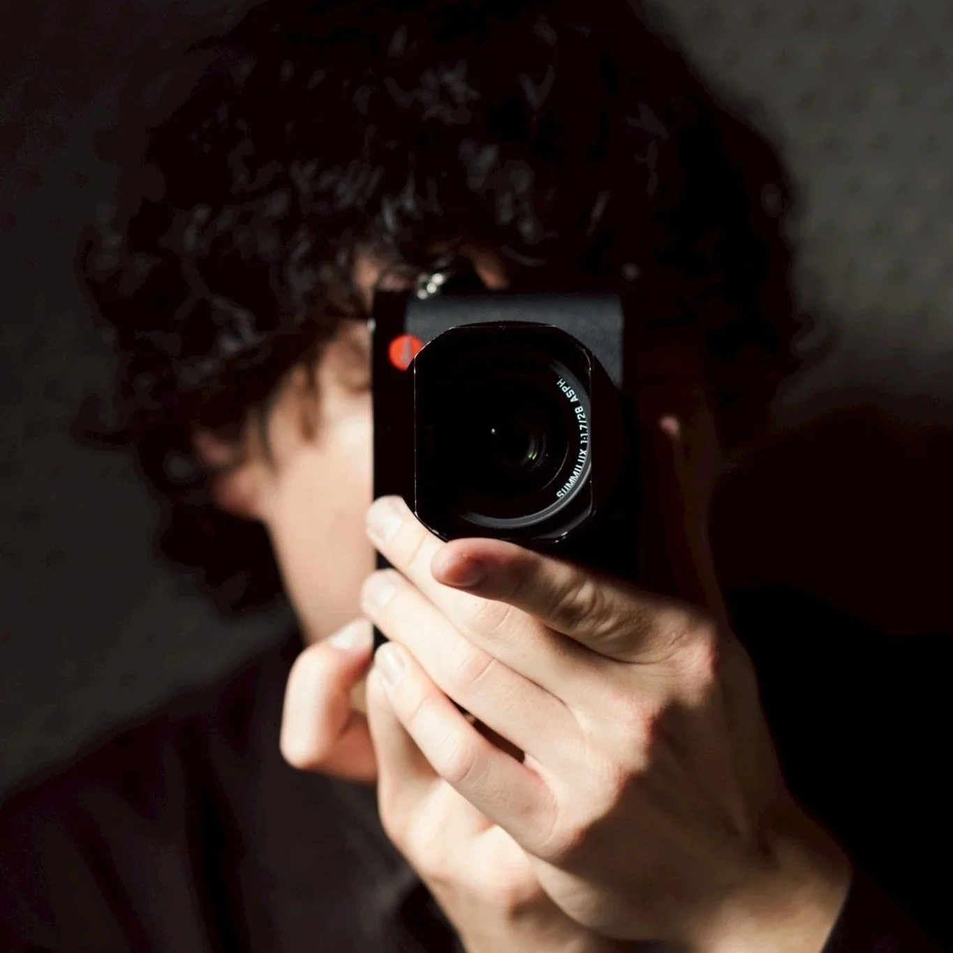 カメラを持った人が鏡の前で写真を撮っている