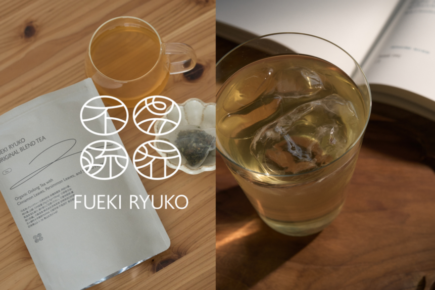 左側に茶色の飲み物が入った透明なマグカップと茶色の木のテーブルの上に置かれた茶色の紙パック、右側にアイスティーの入ったグラスが置かれている。