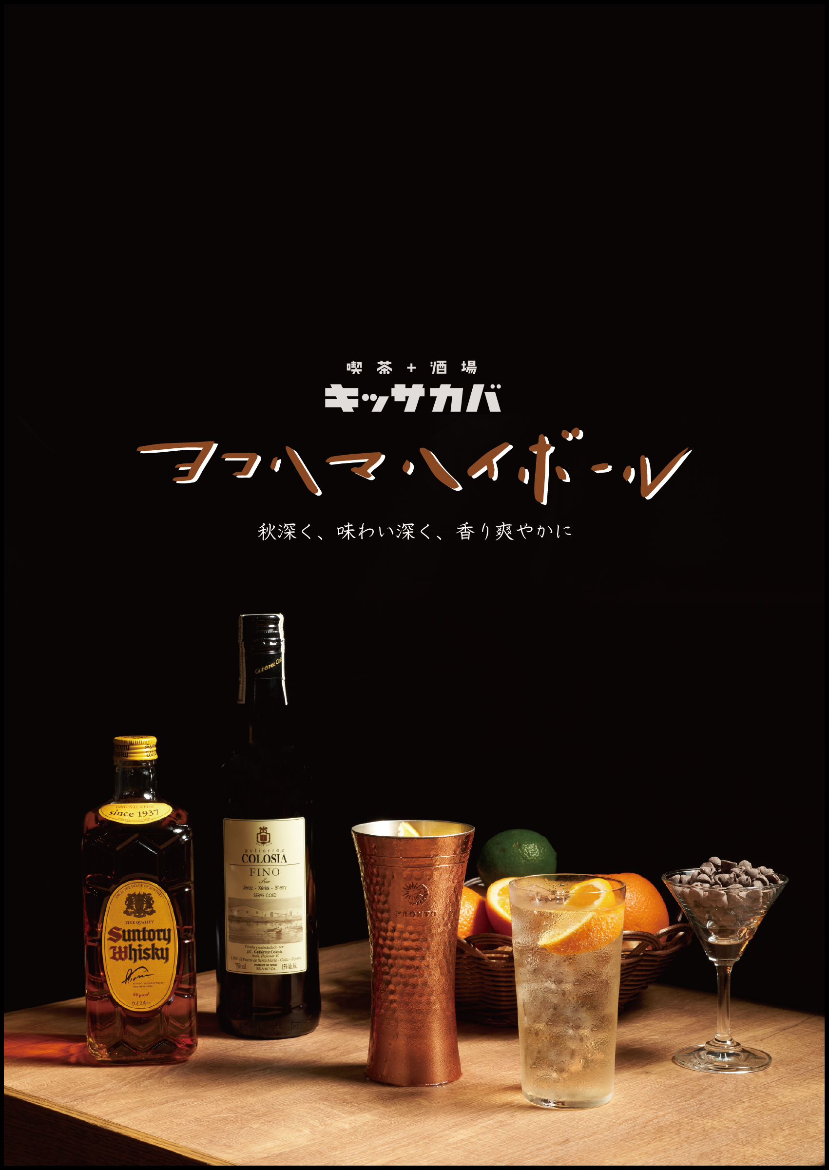 さまざまな飲み物とフルーツを並べたカウンターの写真。左からウイスキーのボトル、白ワインのボトル、金属のカップ、グラスにレモンとオレンジが入ったカクテル、色付きの金属製のカップ、オレンジとライムが並ぶトレー、チョコレートの瓶。