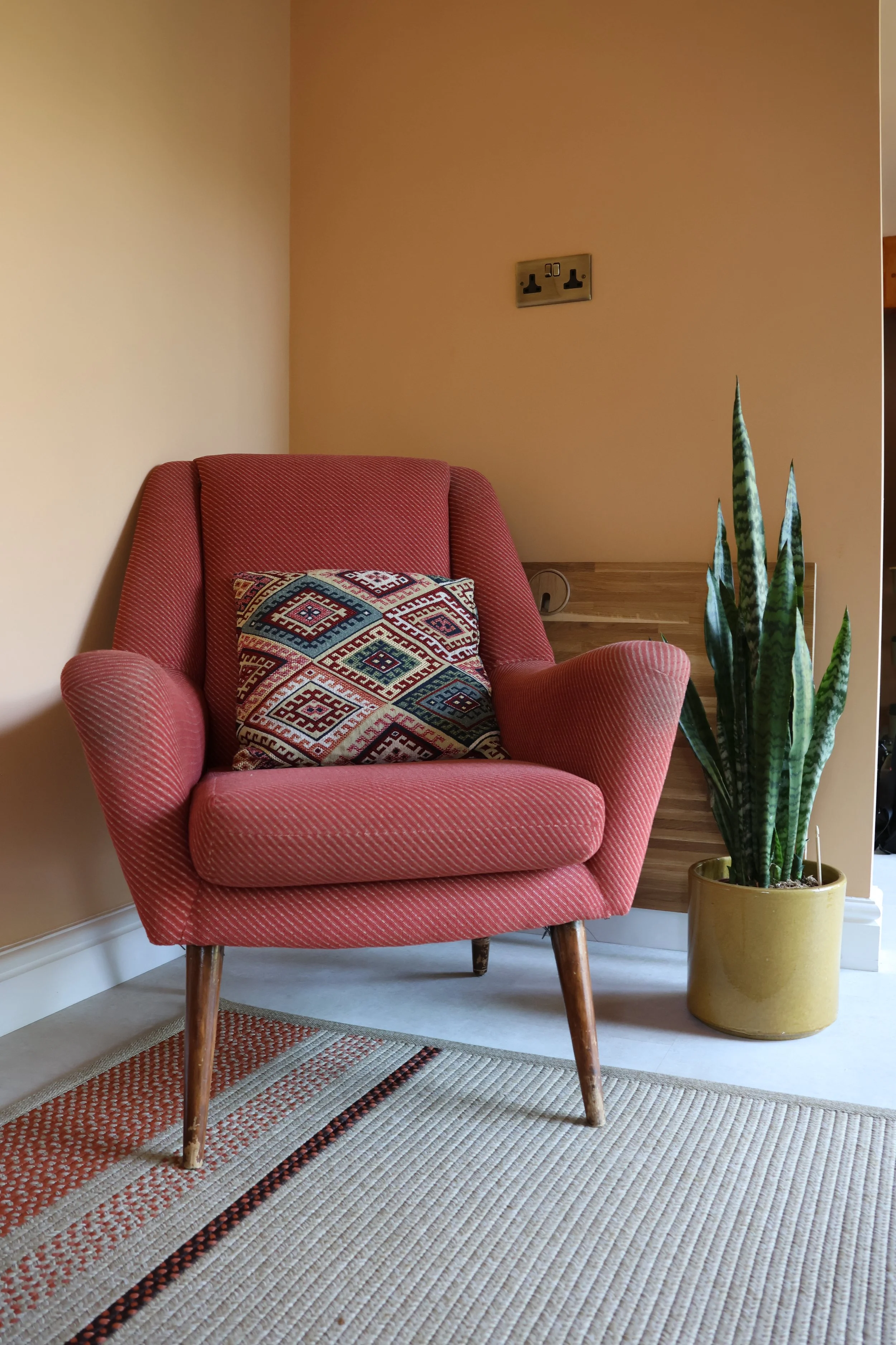 Terracotta armchair in the counselling room at Cedarwood Therapy