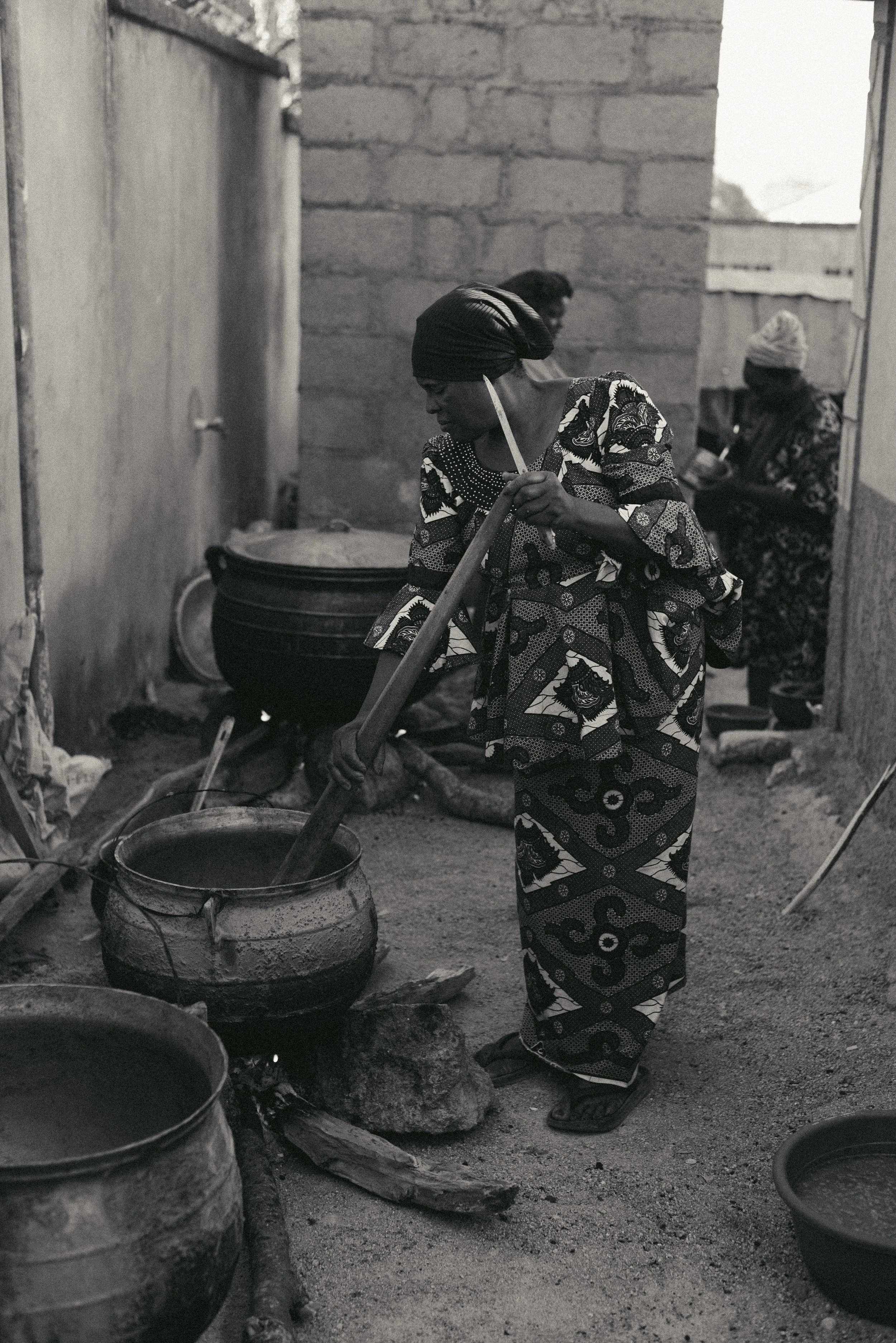 Artisanal preparation in a rustic, atmospheric kitchen with exposed brick walls, where traditional clay cookware highlights the authentic heritage and slow-cooked craft behind SHIKA's cuisine.