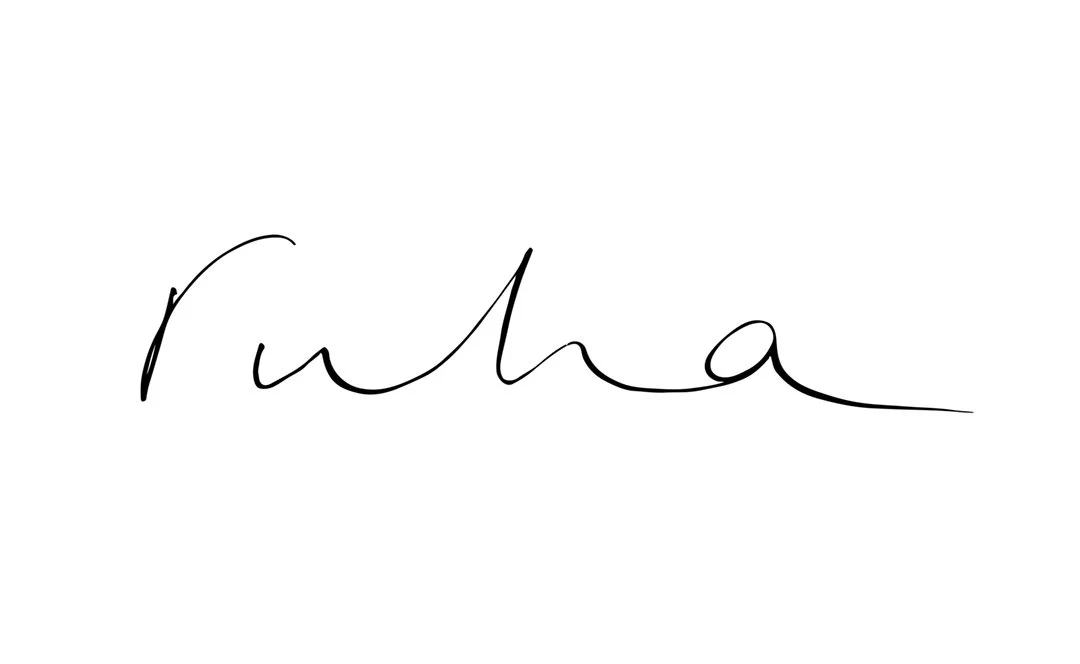 Handwritten text spelling 'Rhea' in cursive
