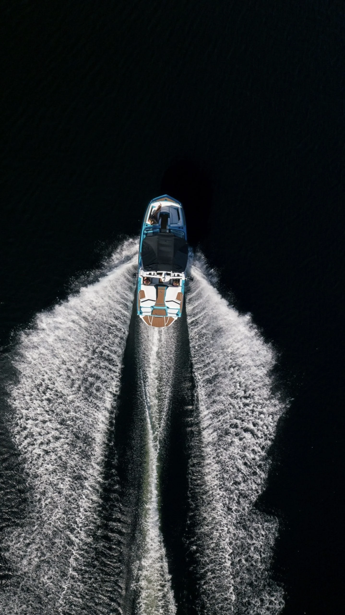 Imagen aérea de un bote navegando por el agua formando una estela