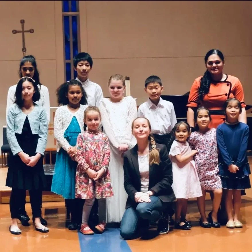Violin teacher with young students after a studio performance.
