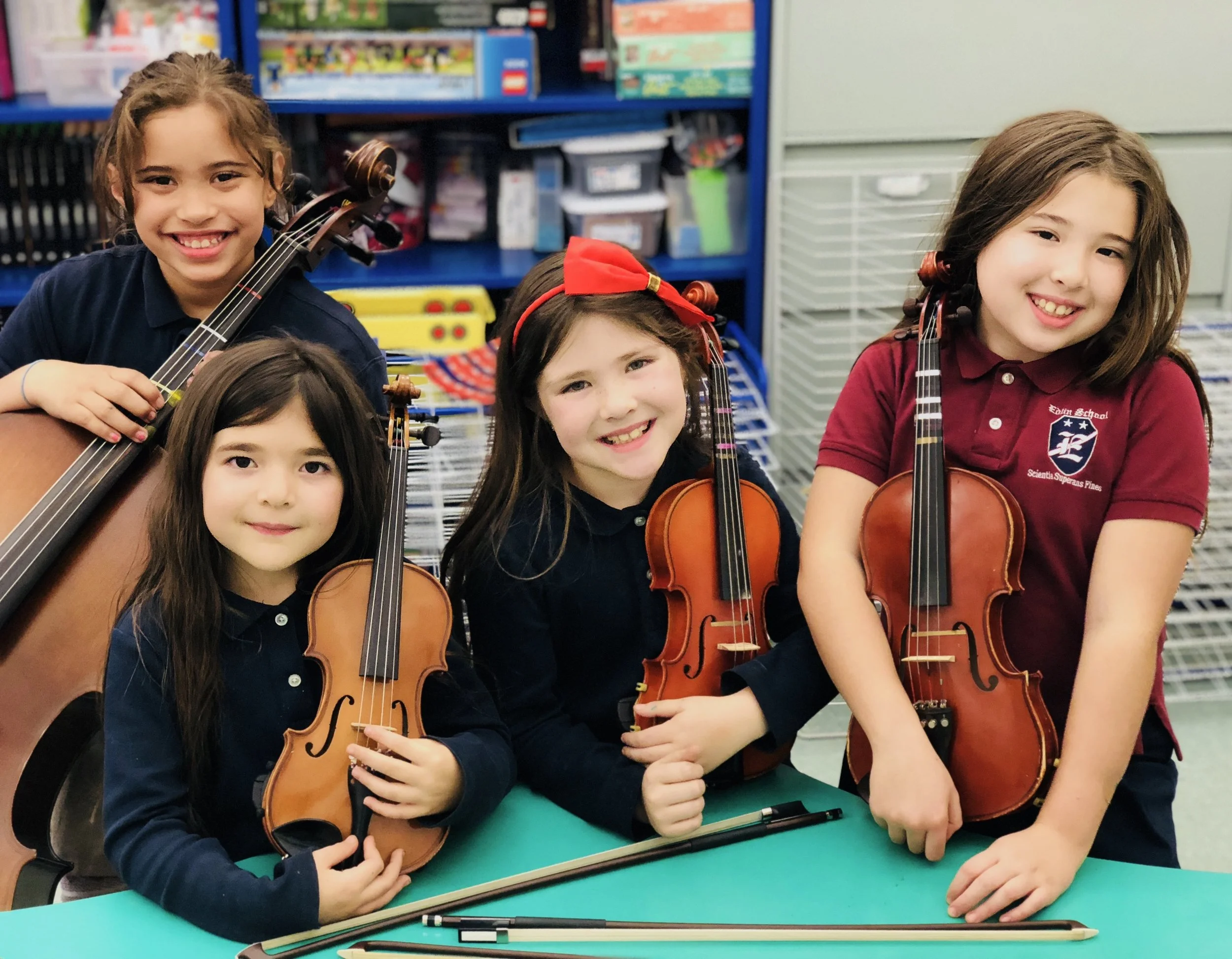 Young violin students with their violins after a group music class