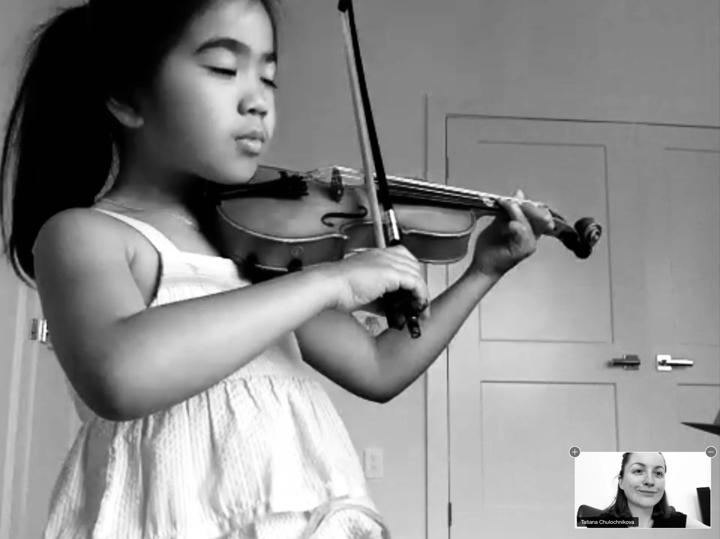 Young violin student enjoying an online violin lesson.