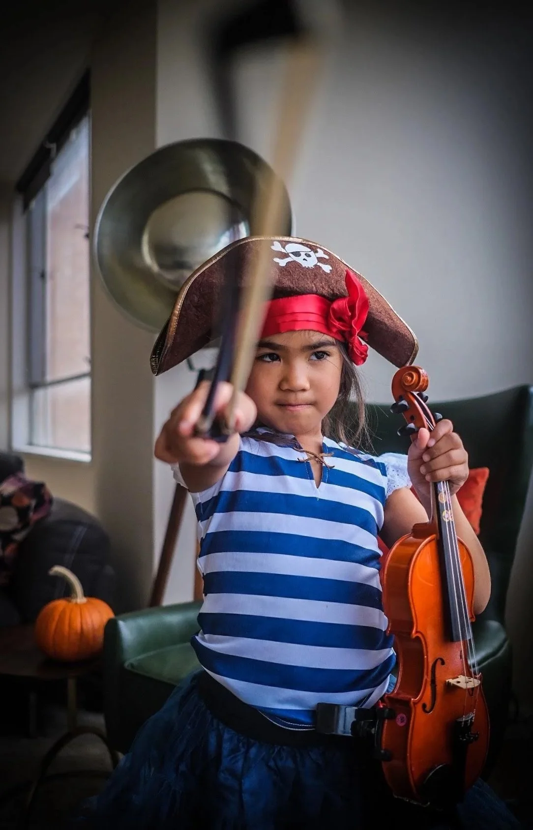 Young violin student in costume holding her violin and bow.