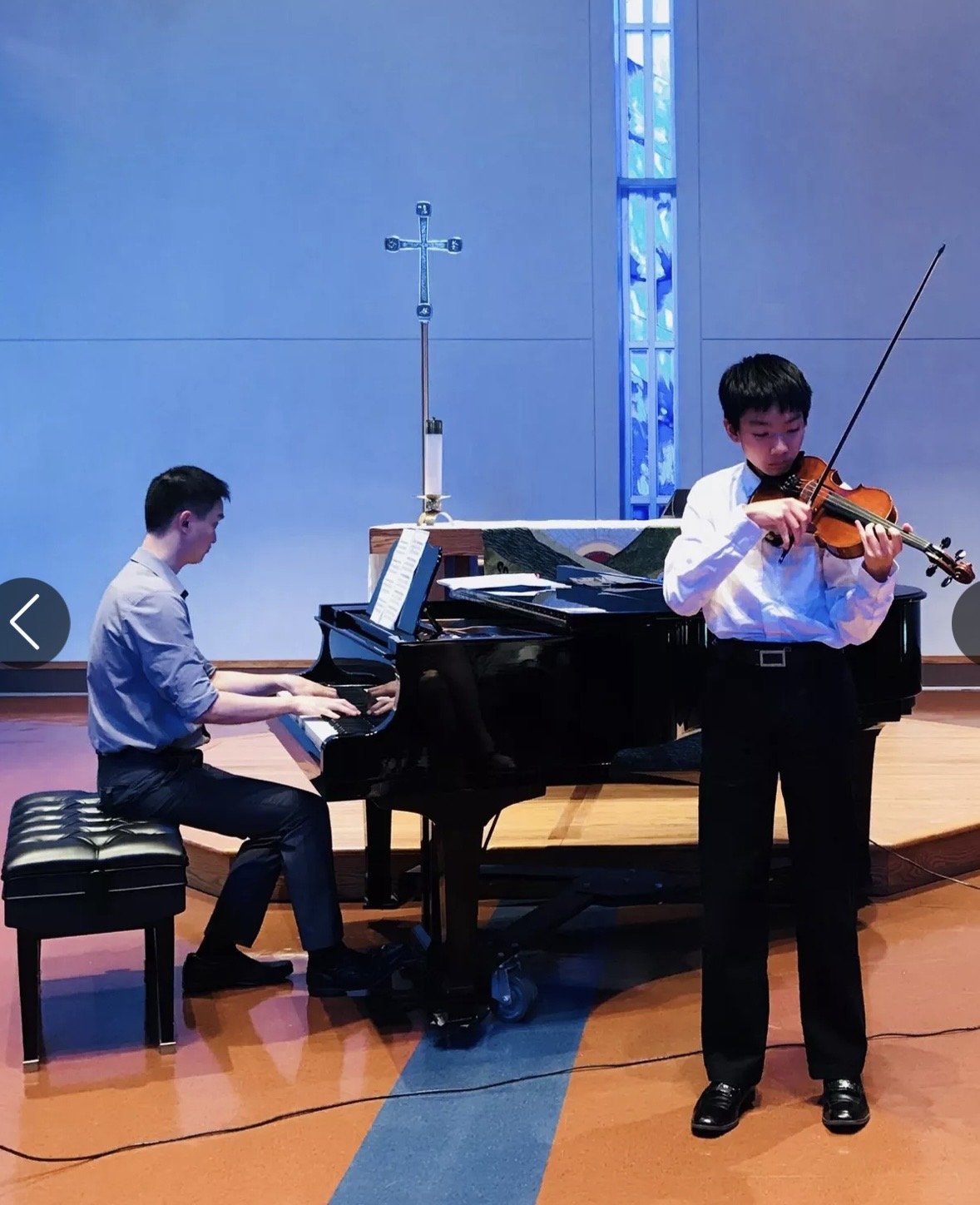 Young violinist and pianist performing together in concert.