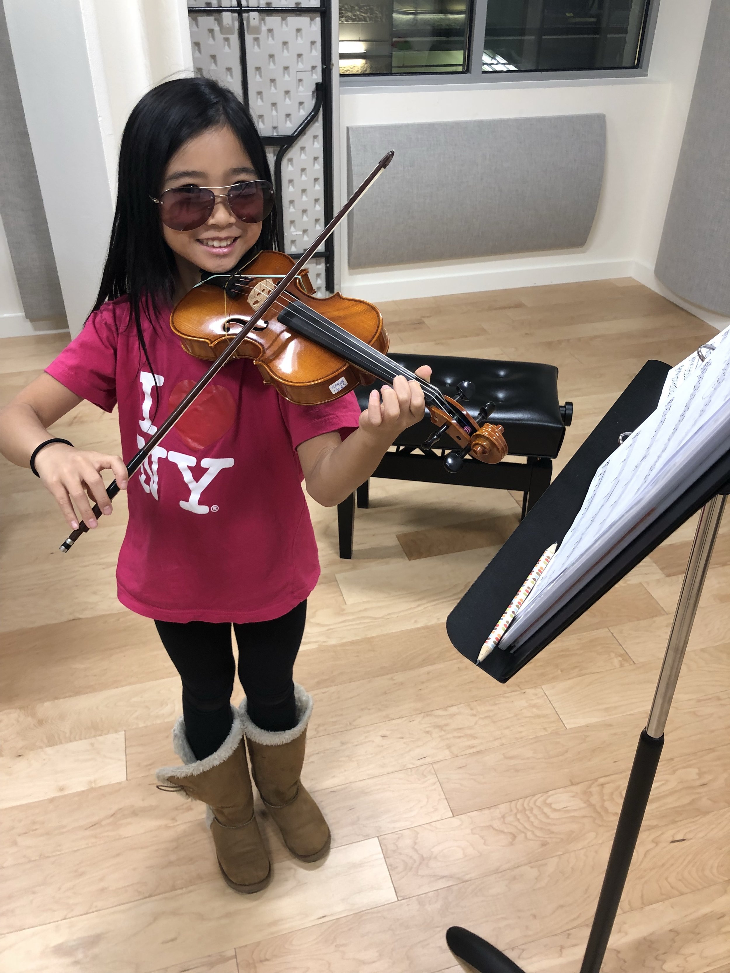 Young violin student practicing in a professional music studio.