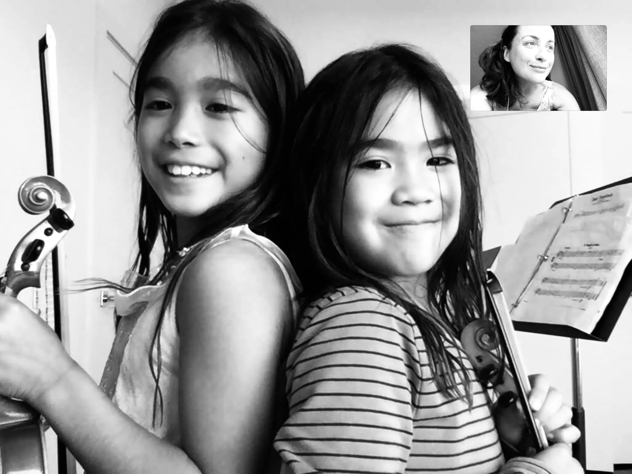 Violin students connecting with their teacher during an online violin lesson.