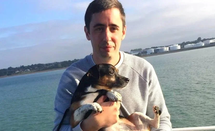 Man holding Jack Russell dog at the beach 