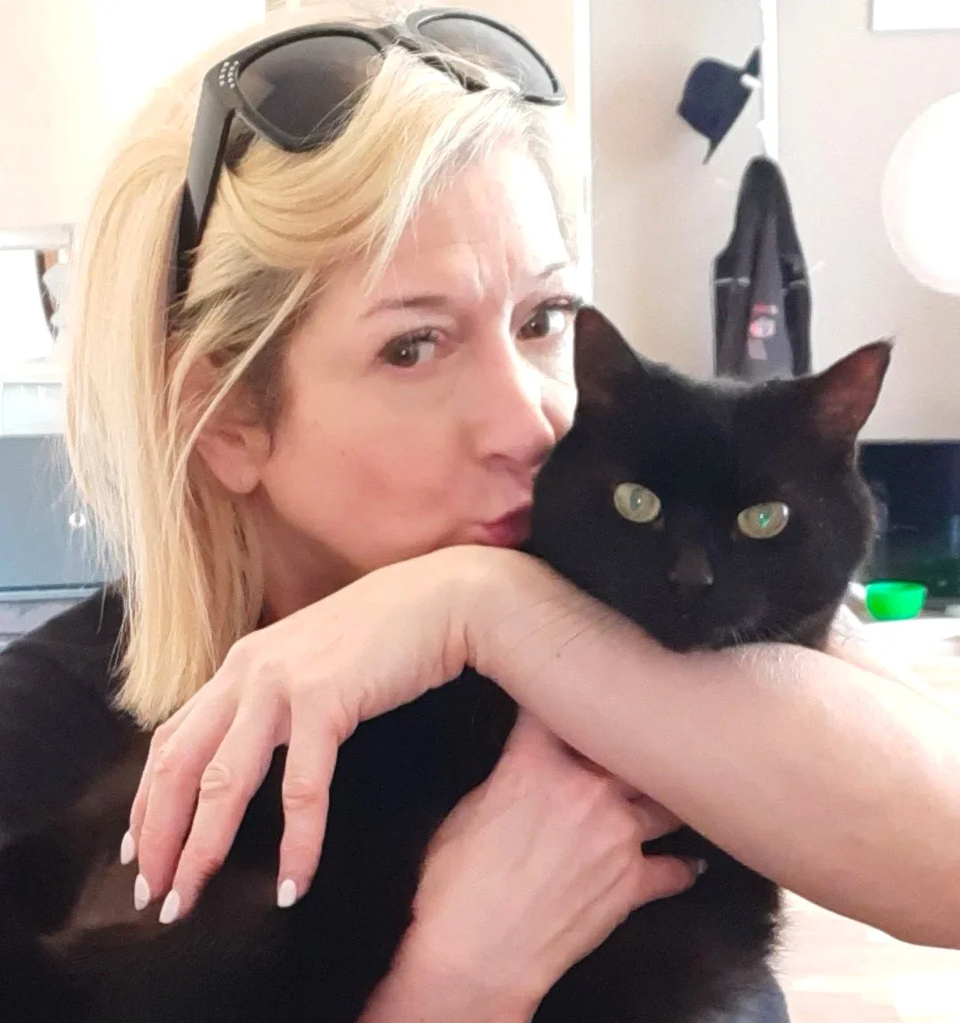 Lady holding her black domestic shorthair cat