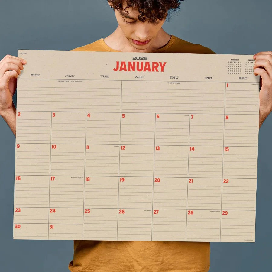 Person holding a 2023 January calendar with a blue background.