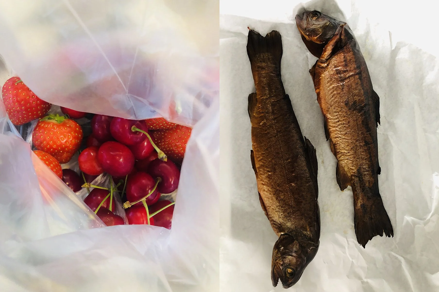 Ein Beutel mit roten Erdbeeren und Kirschen auf der linken Seite; auf der rechten Seite liegen zwei geräucherte Fische auf weißem Papier.