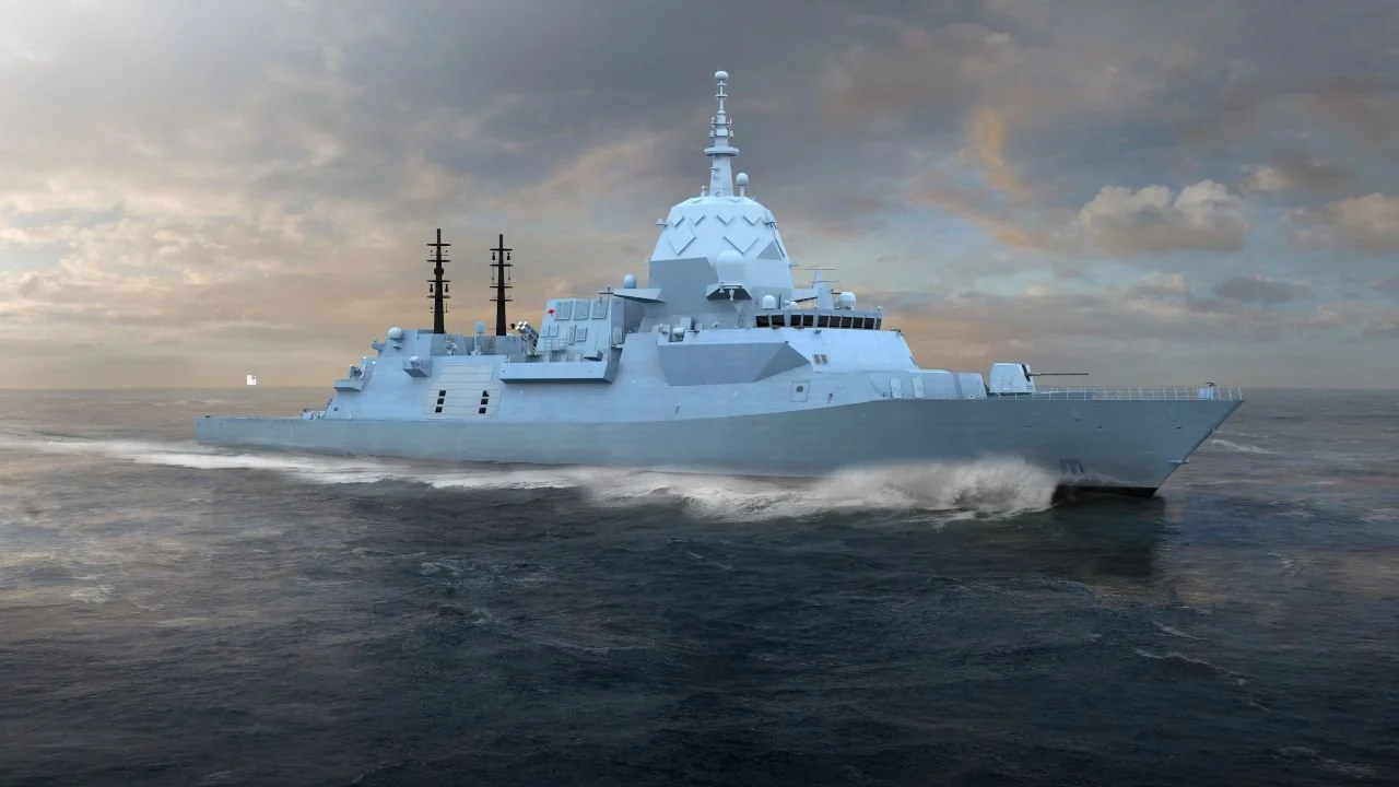 A large modern naval warship sailing on the ocean under a cloudy sky.