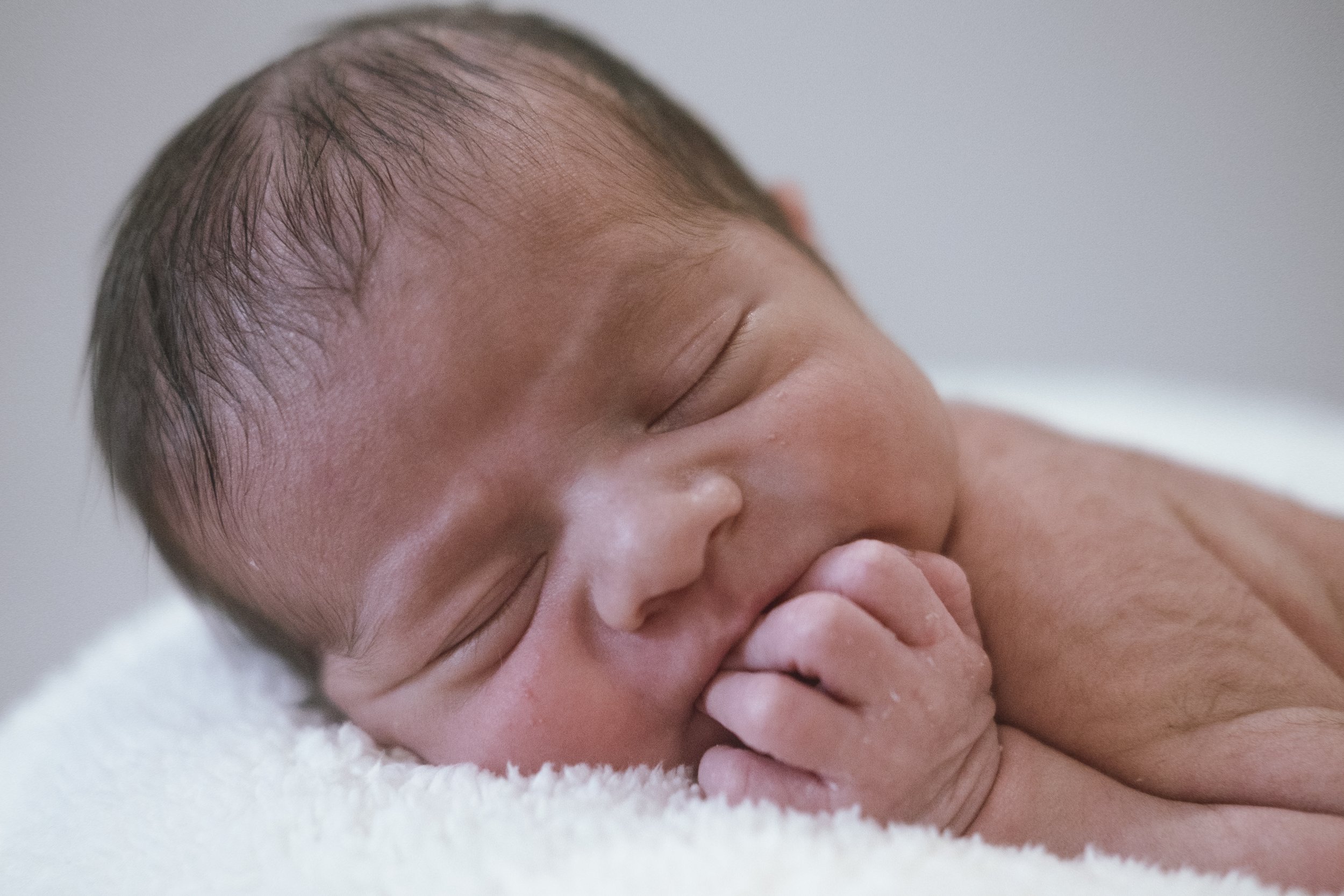 Close-up of a newborn baby peacefully sleeping on a soft surface.