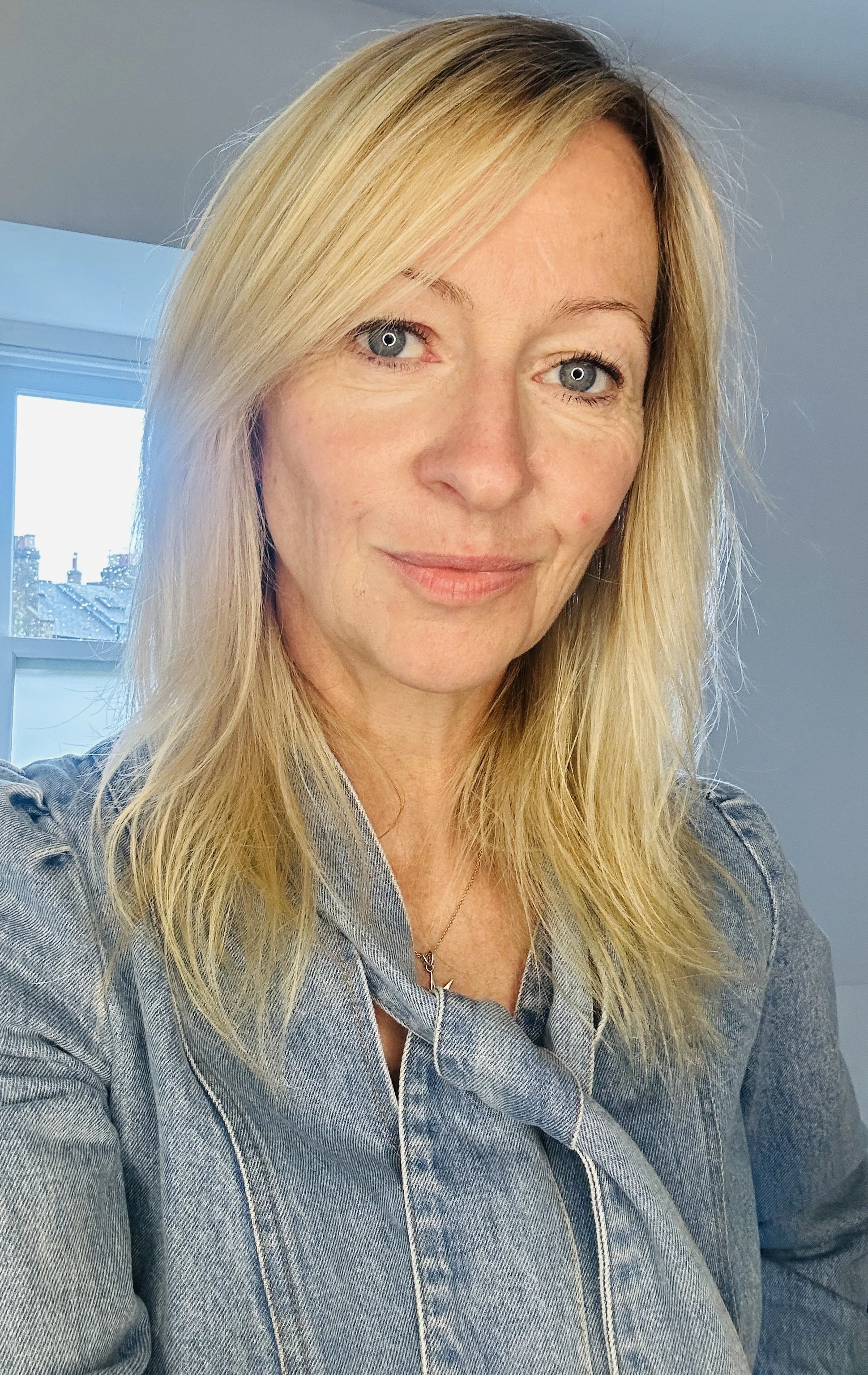 Portrait of Claire Ginzler wearing a denim shirt and necklace.