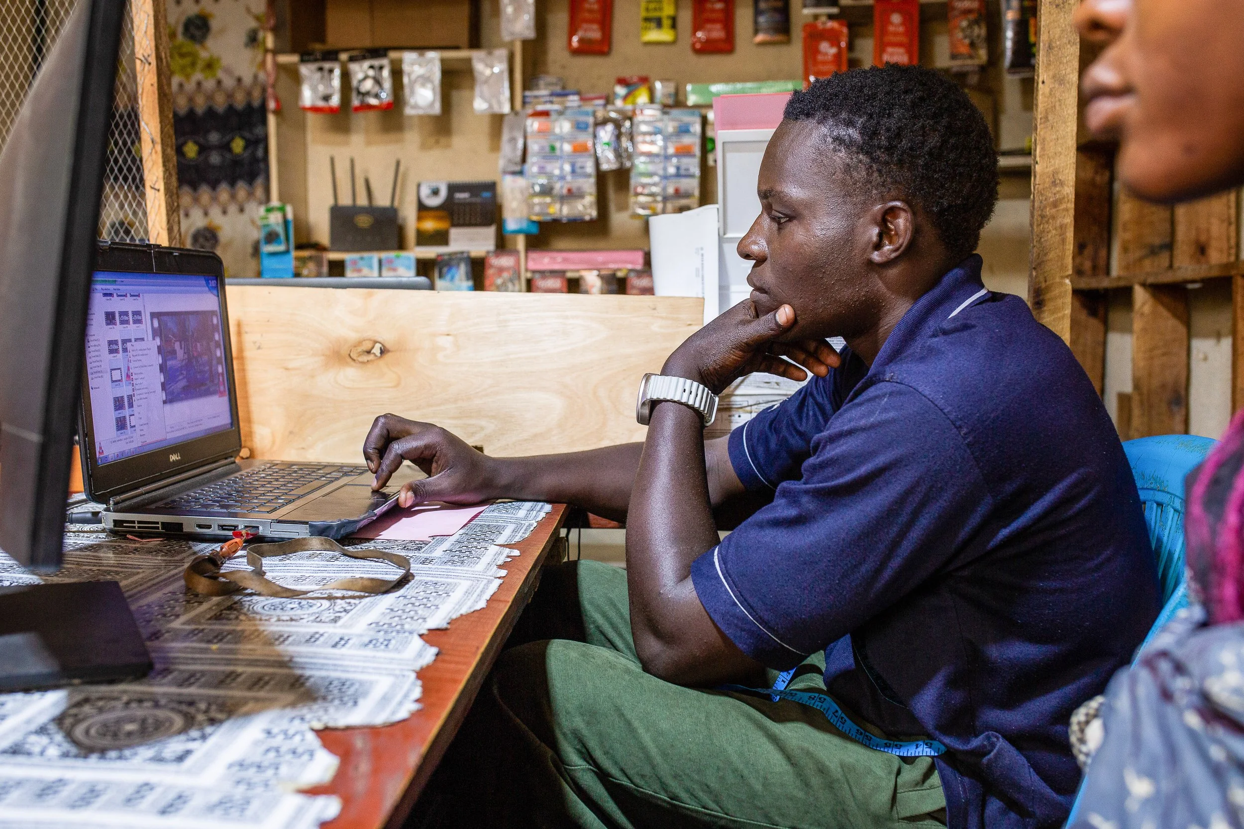 Alfred sits at his desk working on his laptop in his stationery shop