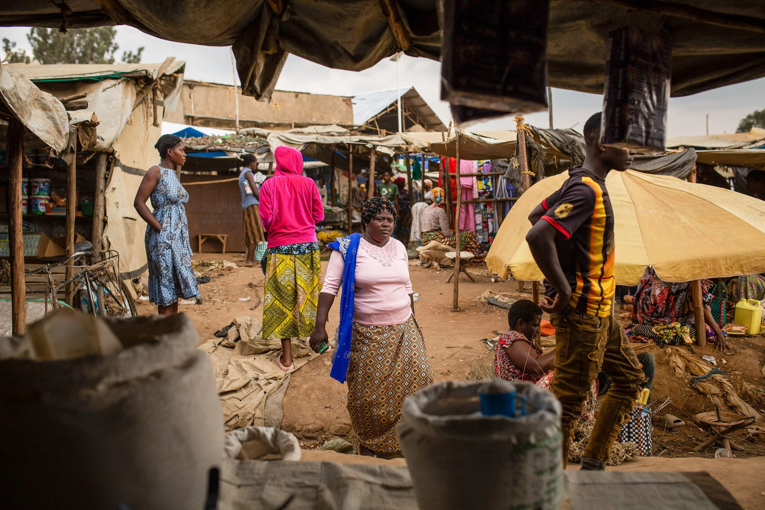 Mediatrice shops in her local market for produce to sell at her shop. 
