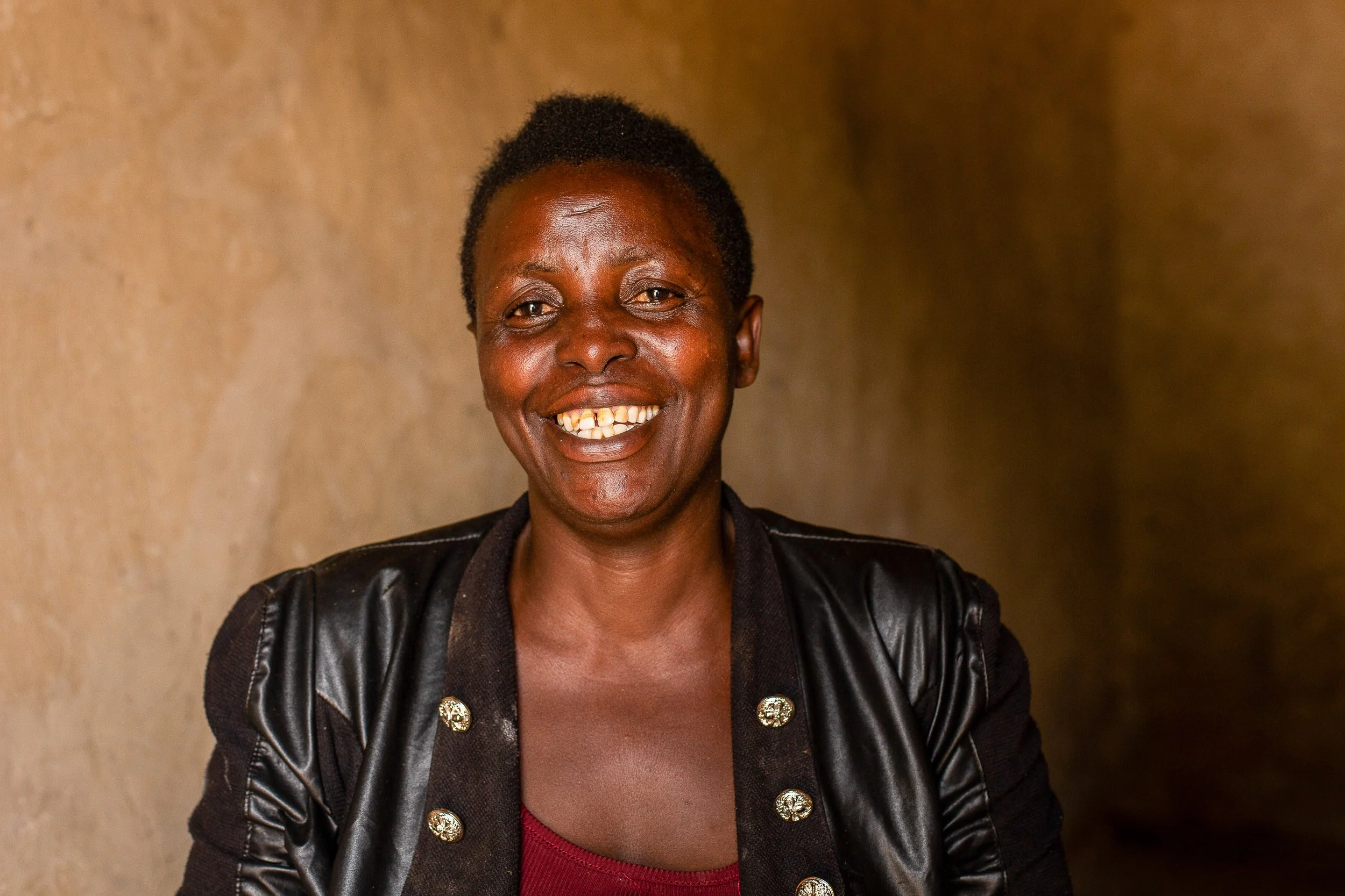 Salama sits indoors and smiles to camera.