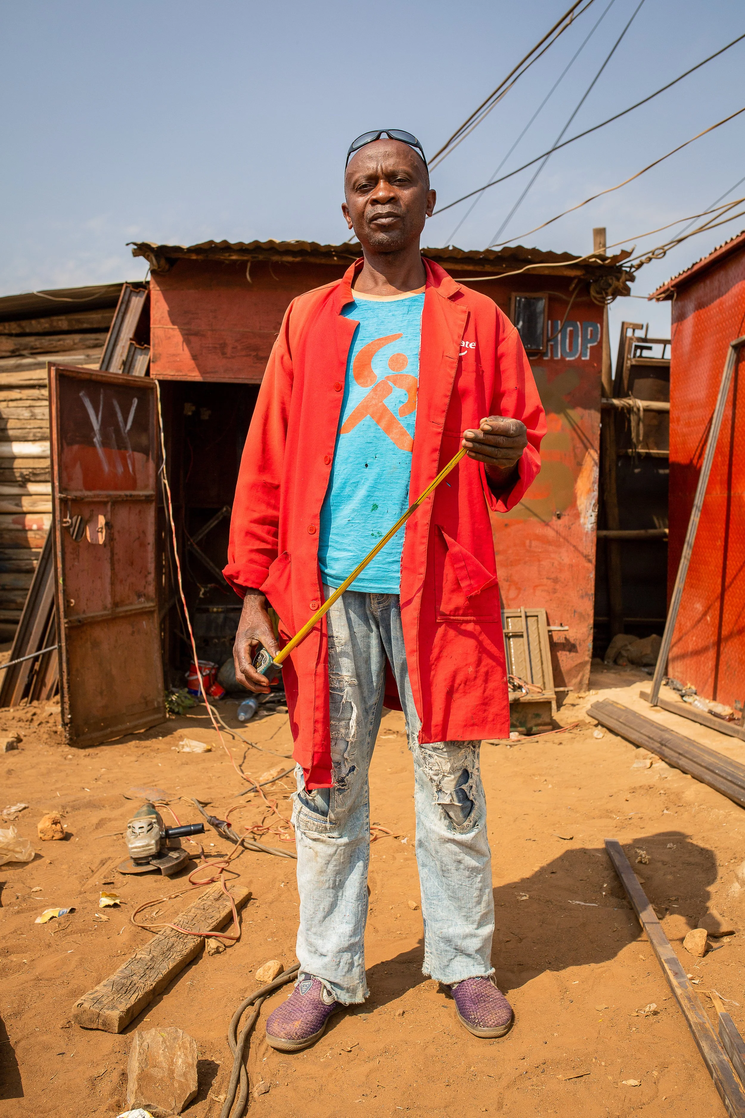 Luhavu looks to the camera wearing a bright red coat and protective glasses on his head.