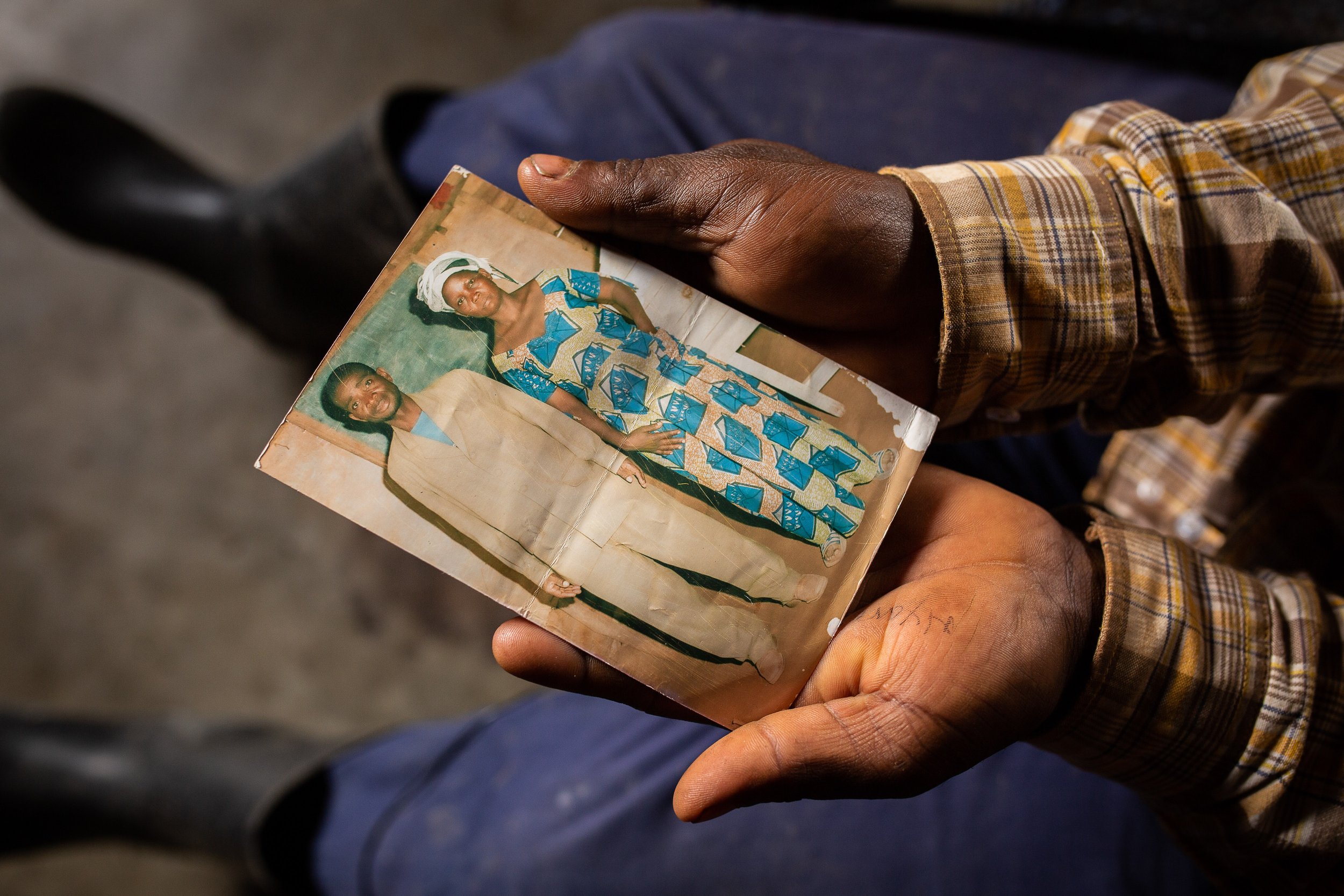 Joshua cradles a photograph of his parents in his hands.