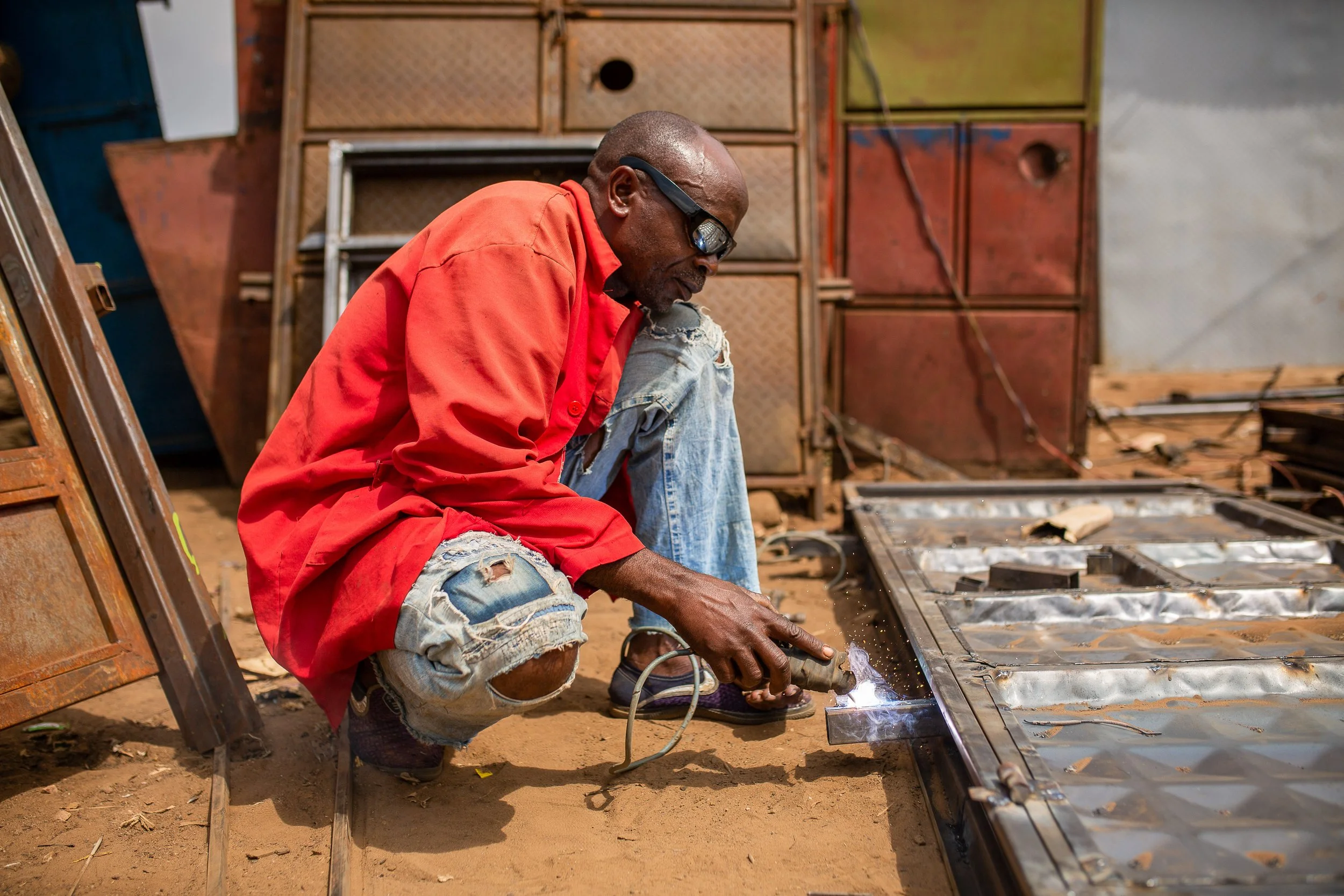 Luhavu welds some metal at his metalworking shop