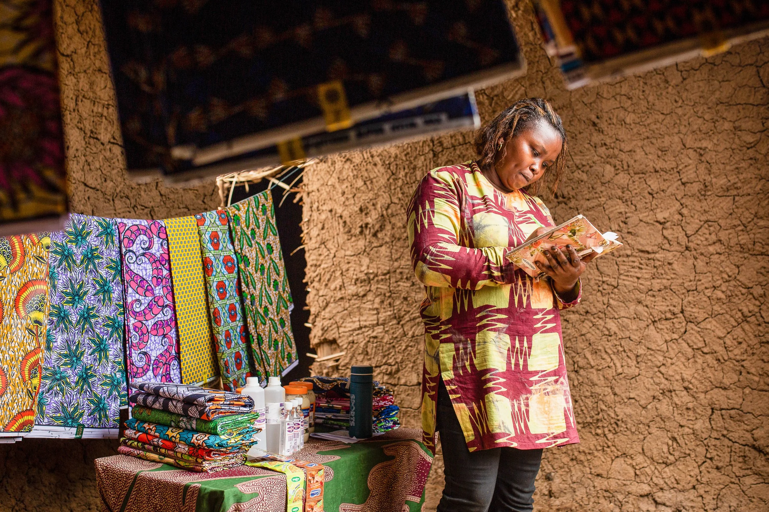 Furaha does the bookkeeping at her bitenge shop.