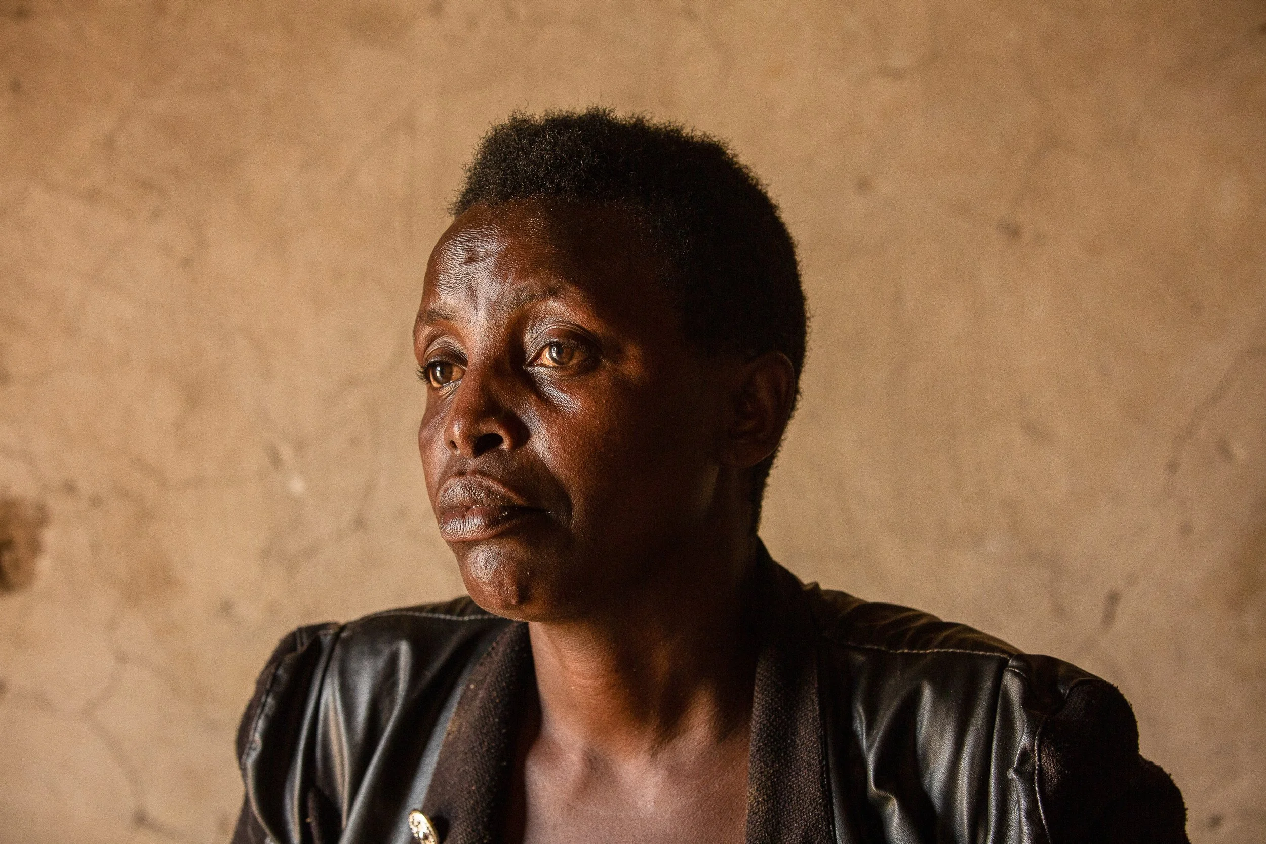 Salama sits inside her home and looks off into the distance.