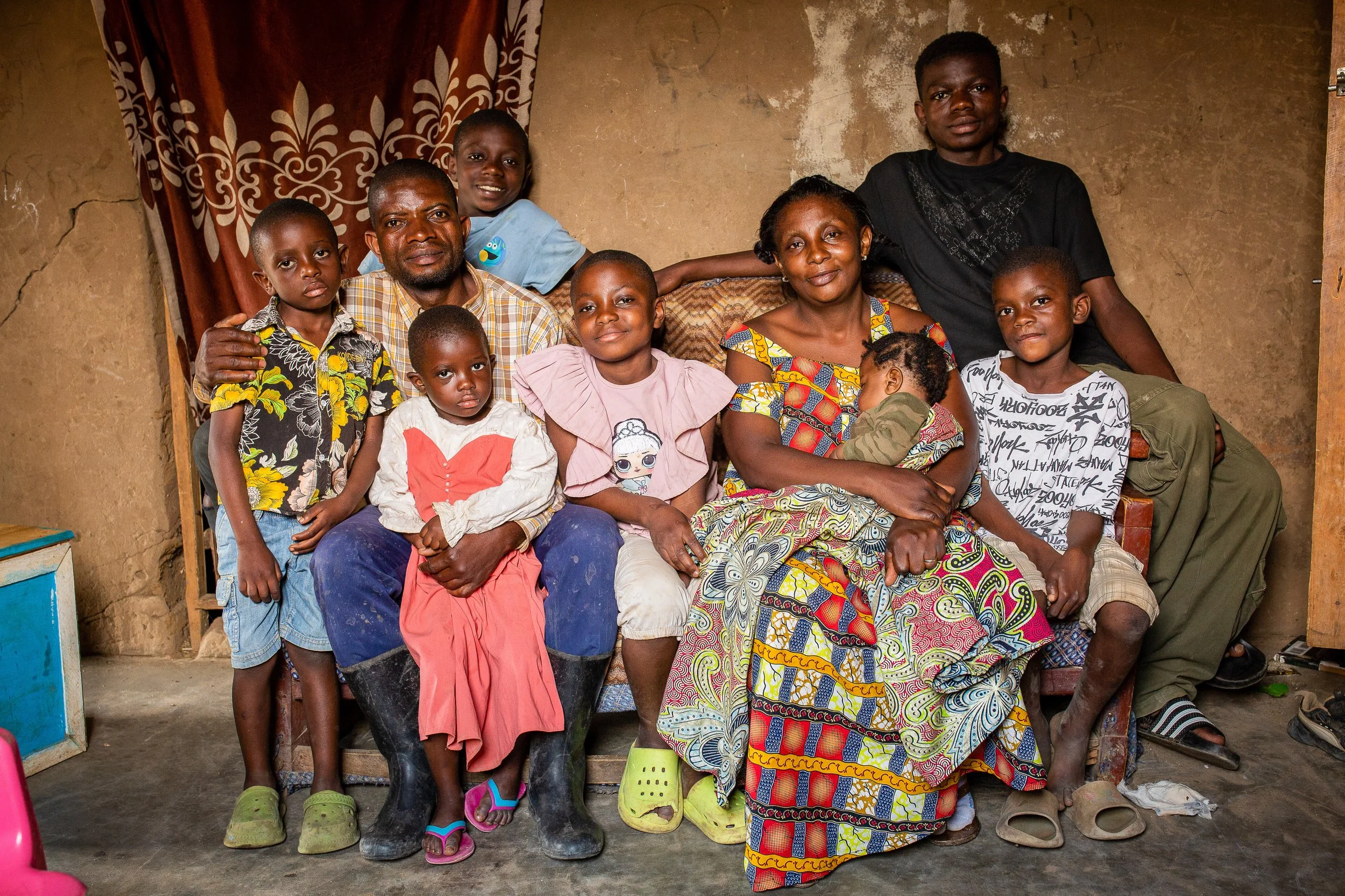 Joshua sits with his wife and children.