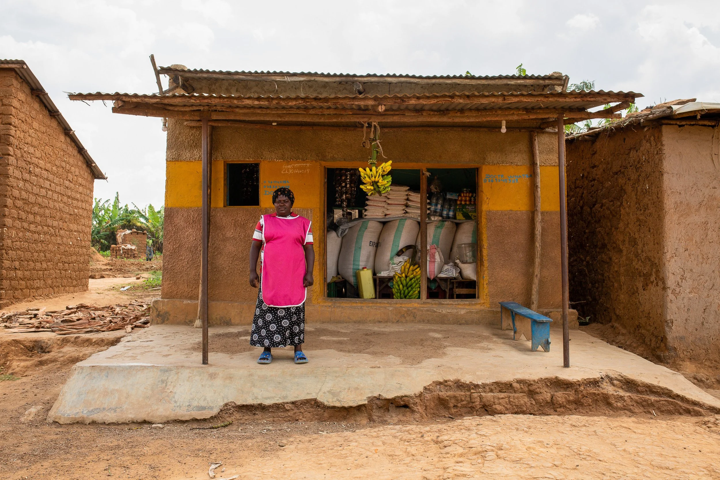 Mediatrice stands outside her shop. 