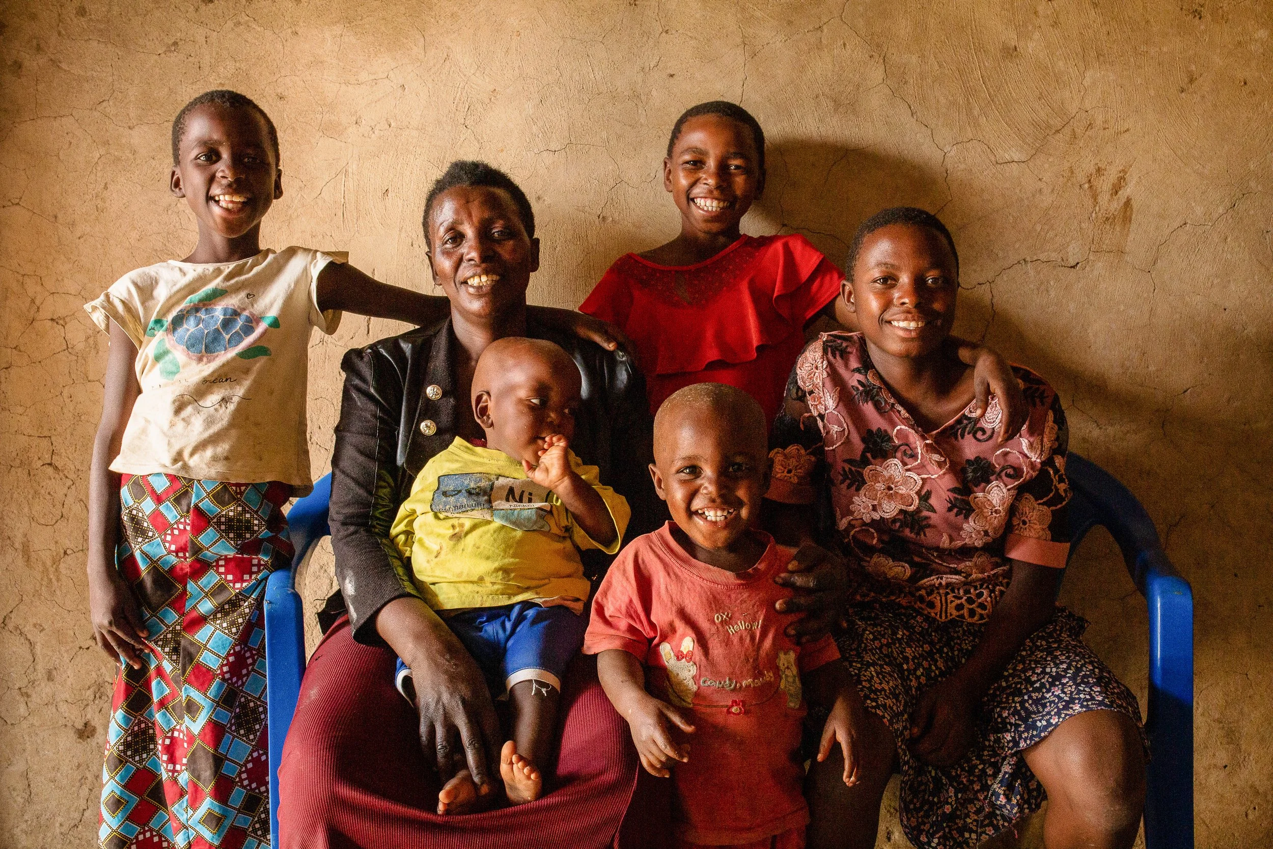 Salama and her five children sit together for a photograph smiling.