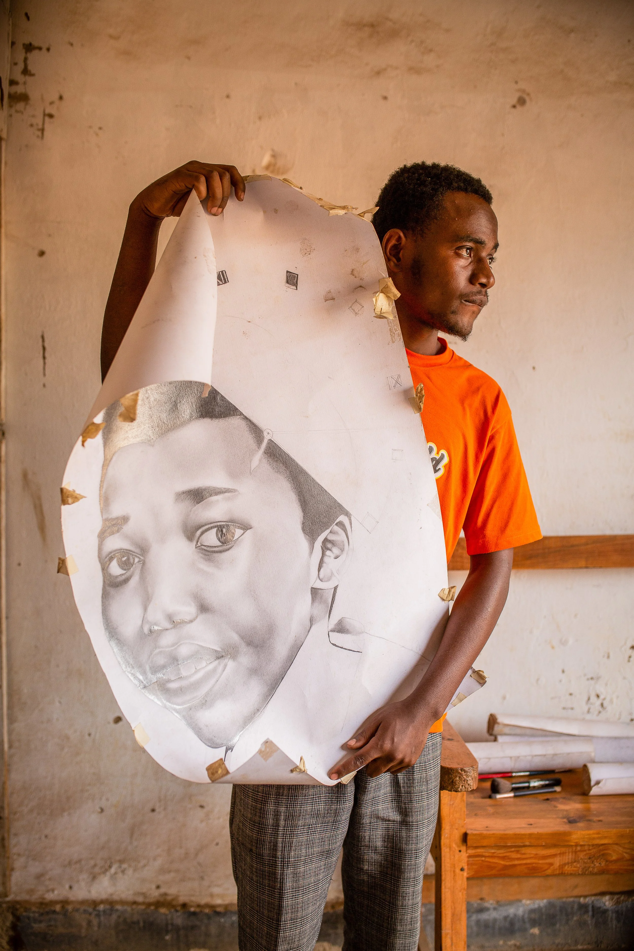 Savino shows off one of his drawings, a pencil sketch of a woman's face