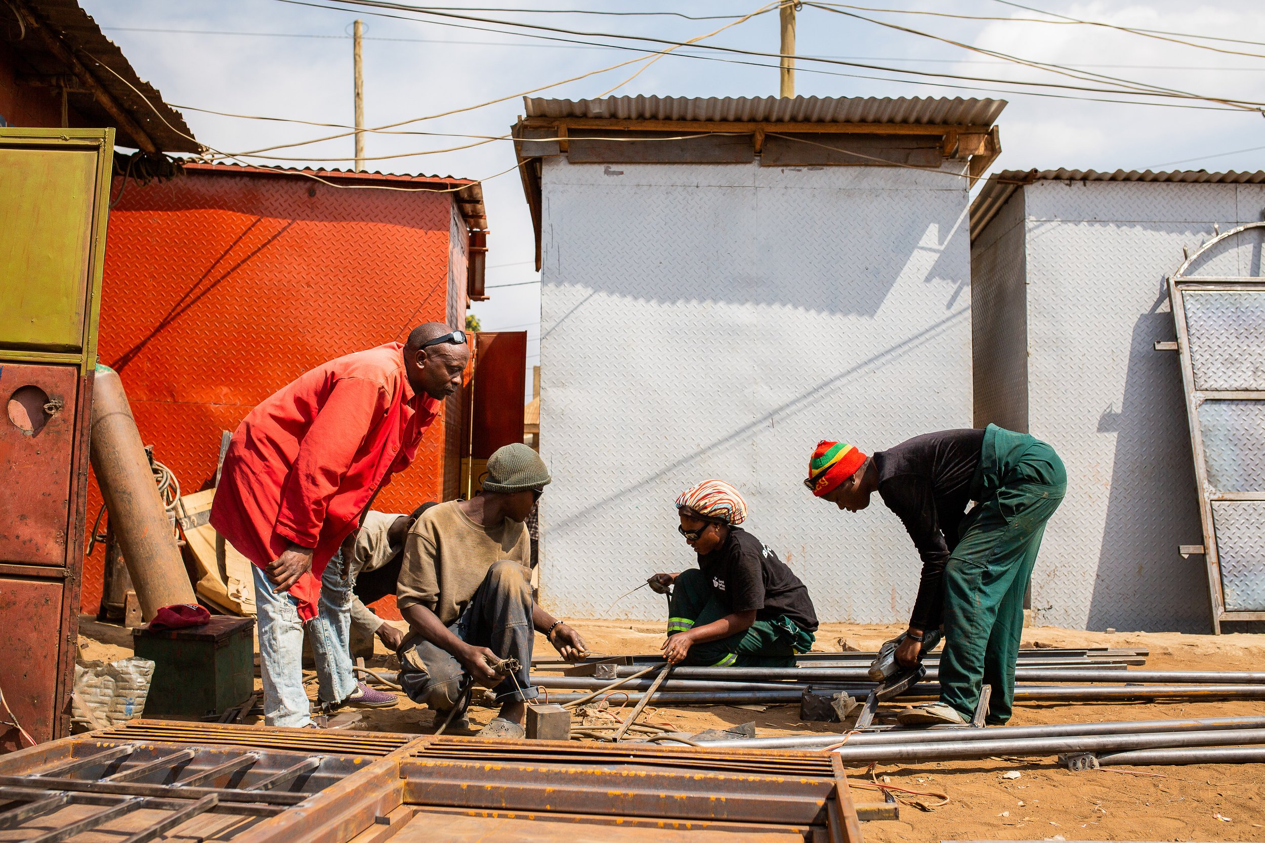 Luhavu, a refugee in Uganda, works with a group of young employees at his metalworking shop.