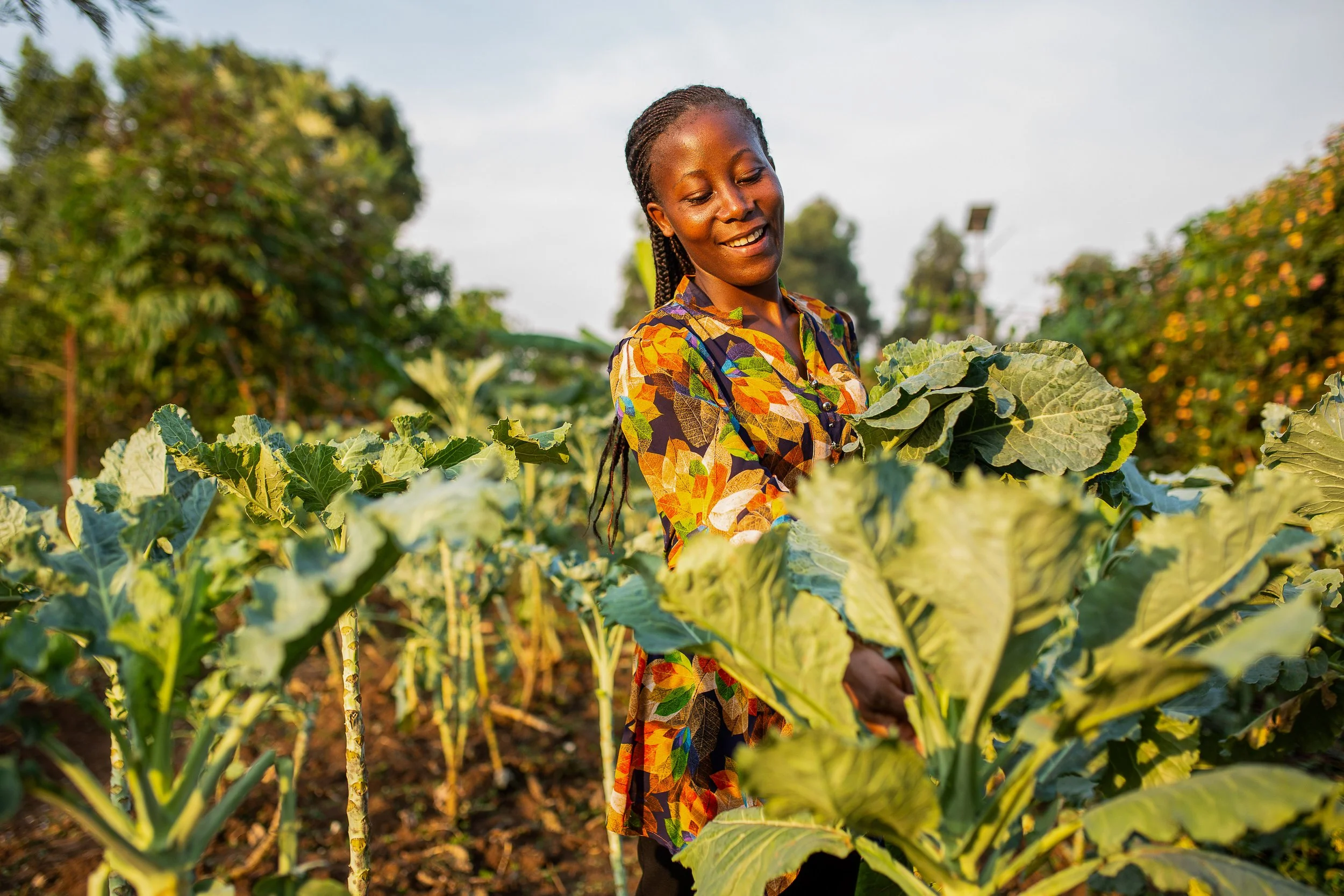 Ruth smiles as she tends to her kale crop