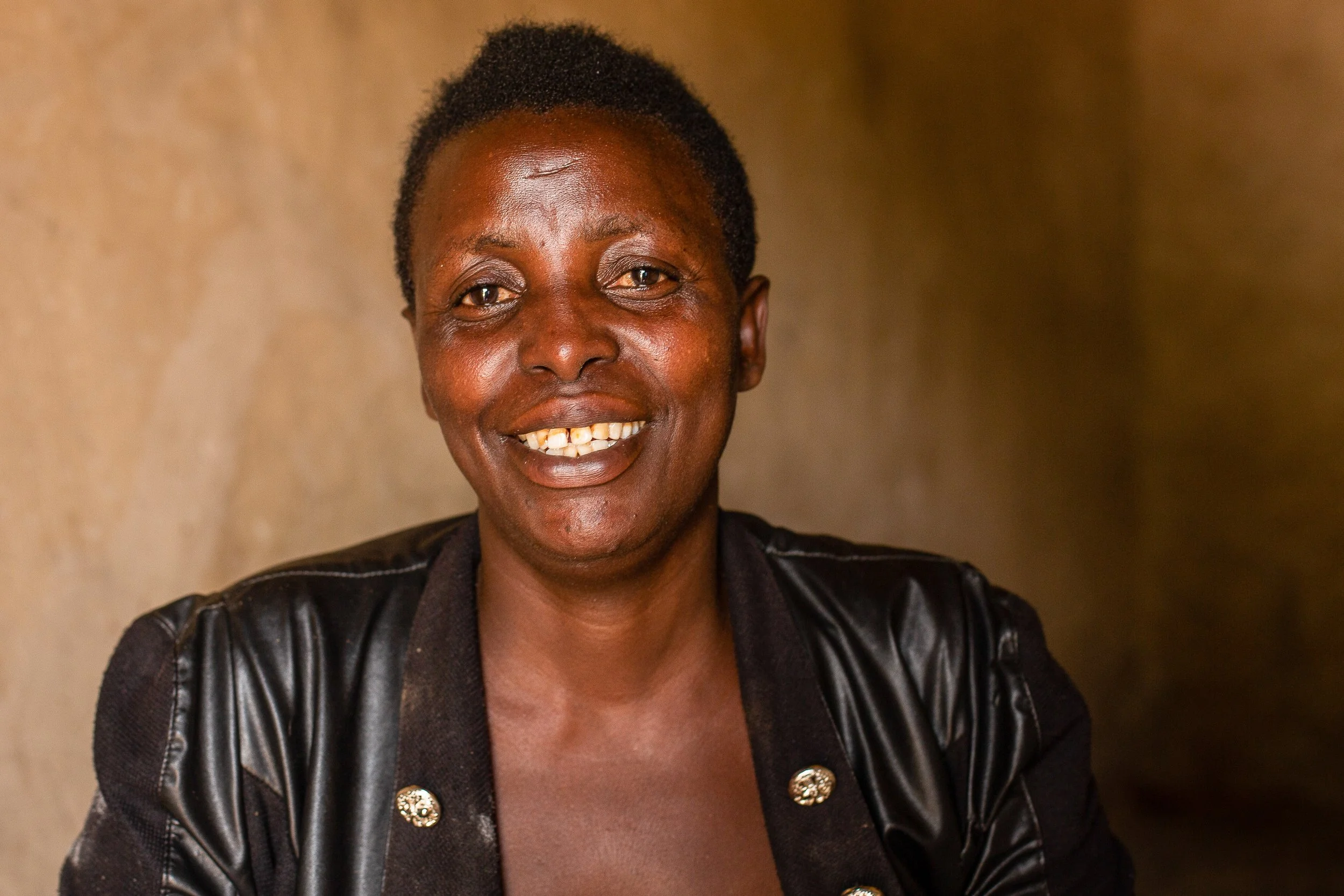Salama sits indoors and smiles to camera.