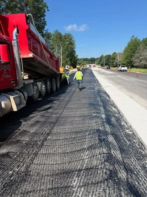 red truck pouring asphalt onto road