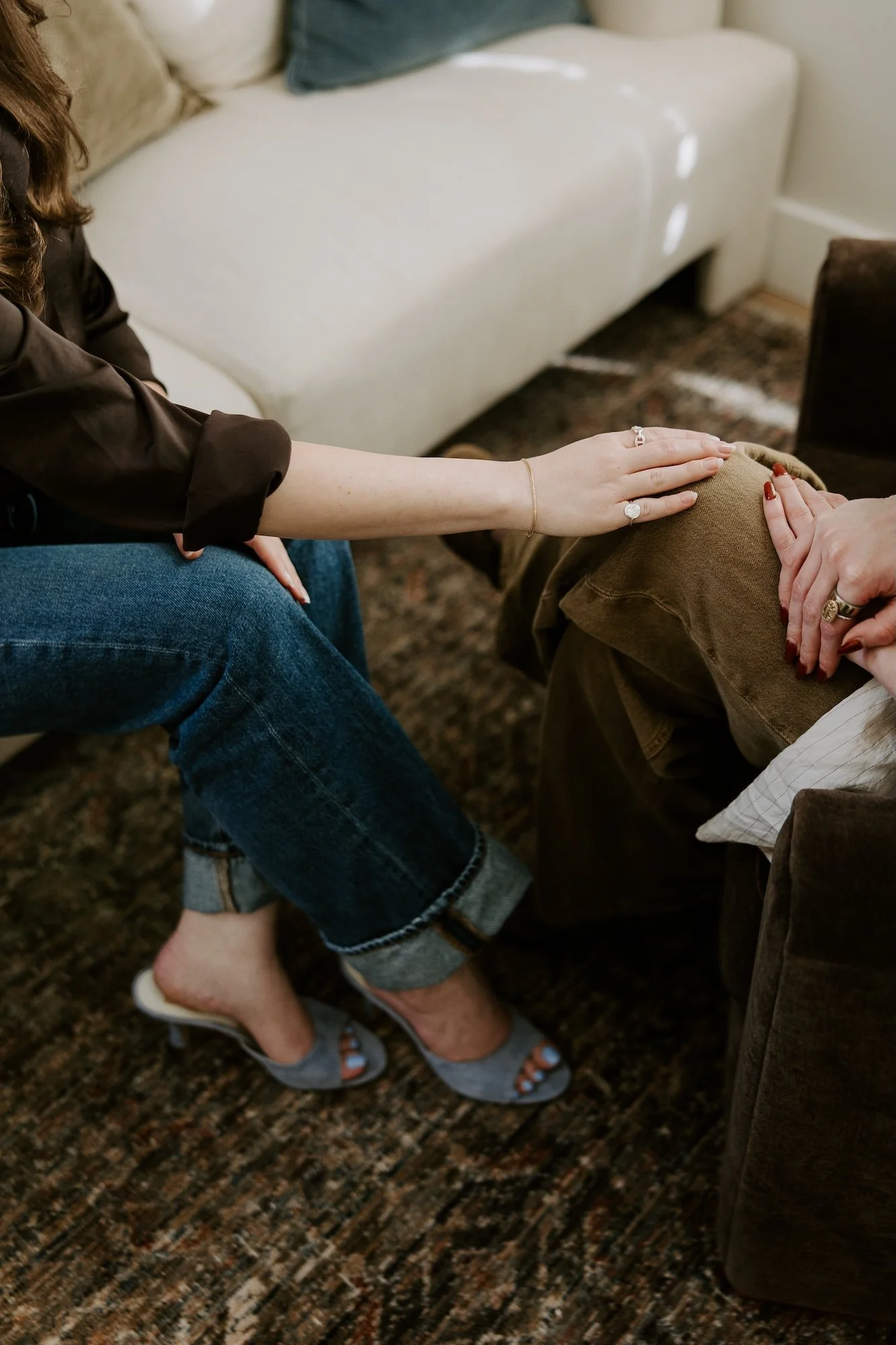 A therapist offering a grounded gesture of emotional support and somatic presence during a therapy session