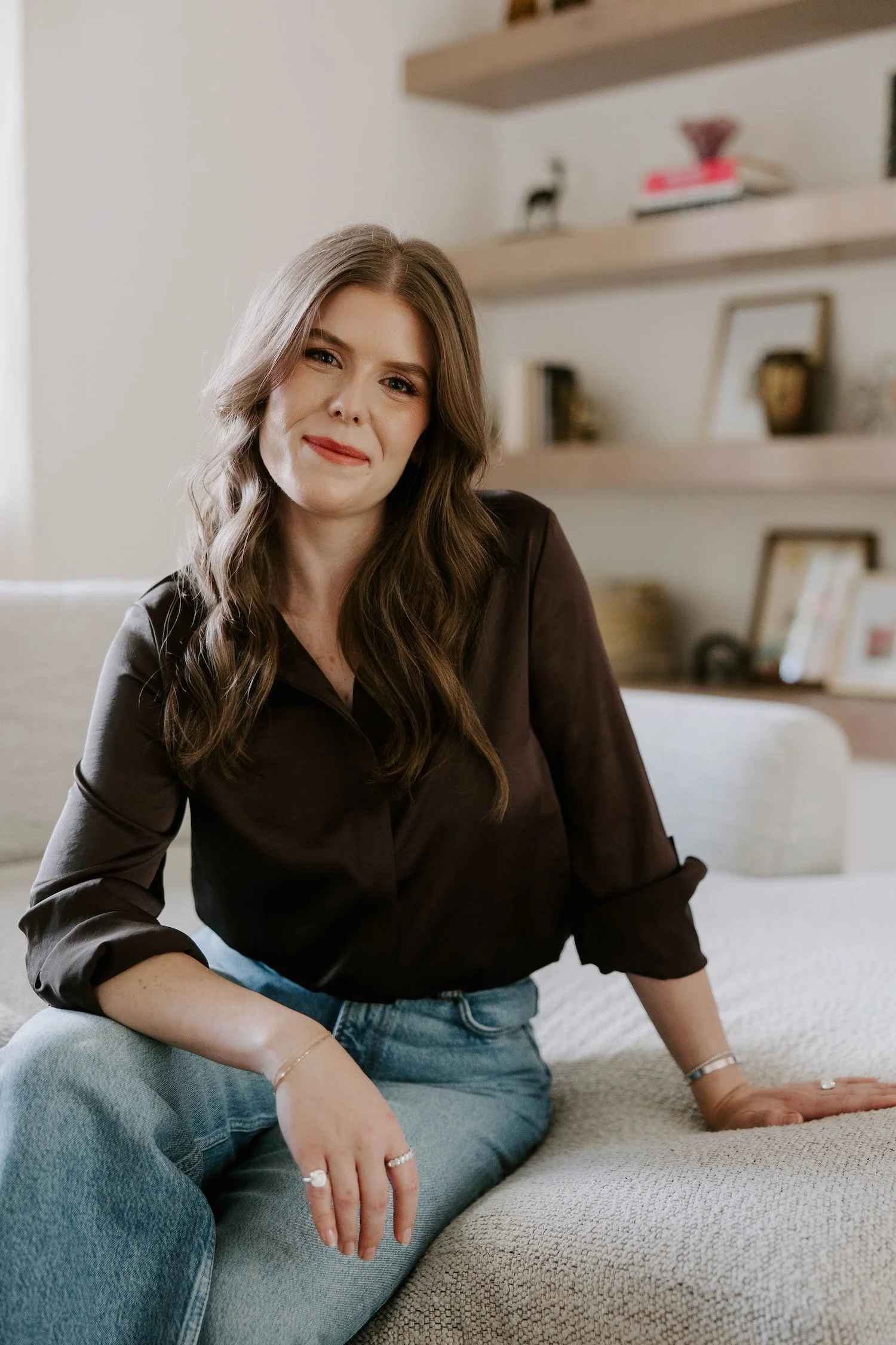 Chadley Zobolas, Denver trauma and attachment therapist, smiling while seated on a cream couch