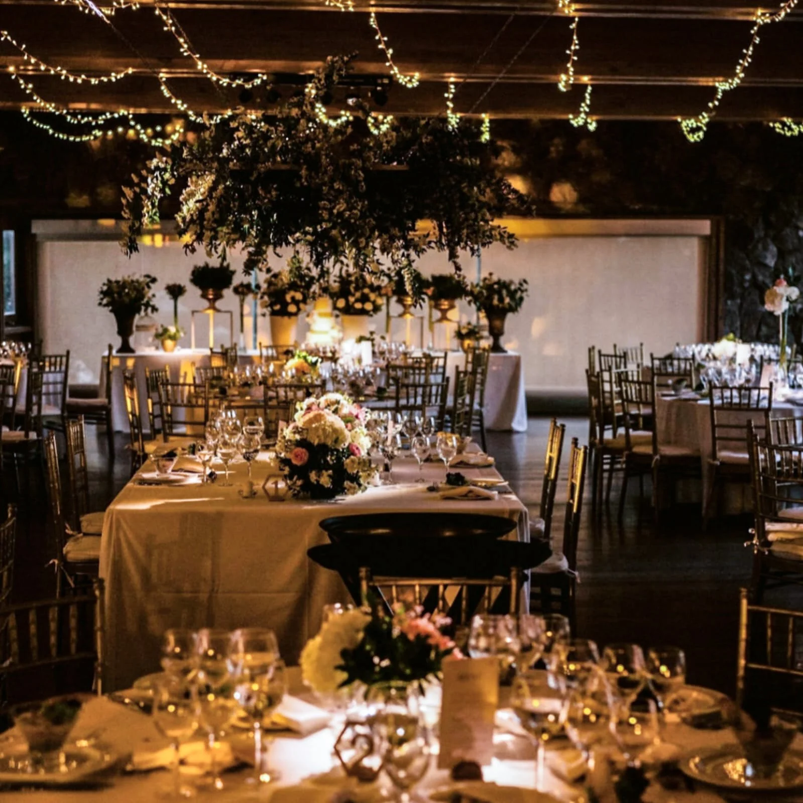 Ambientación para matrimonio con guirnaldas de luces hada, arreglos florales y mesas elegantemente decoradas por L'Orangerie.