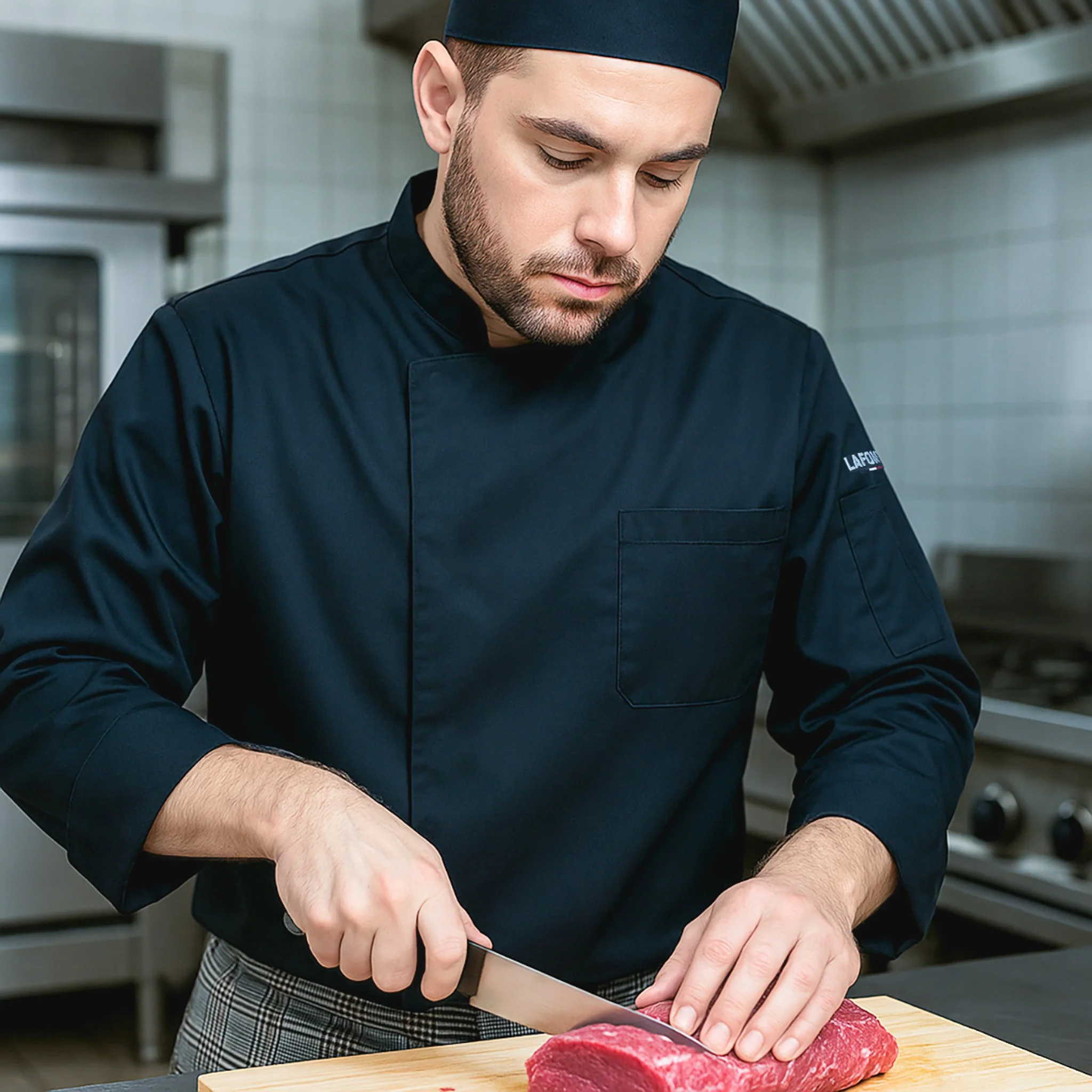 Chef préparant de la viande crue sur une planche à découper de cuisine.