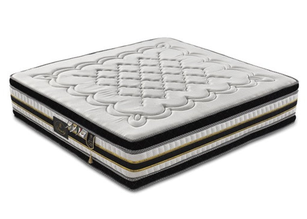 A white and black mattress with gold accents, detailed quilting, and a tag on its side.